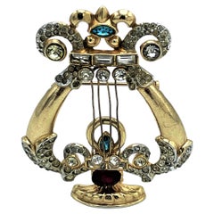 Coro brooch in the form of a string instrument, rhinestones, g. plated, 940s US
