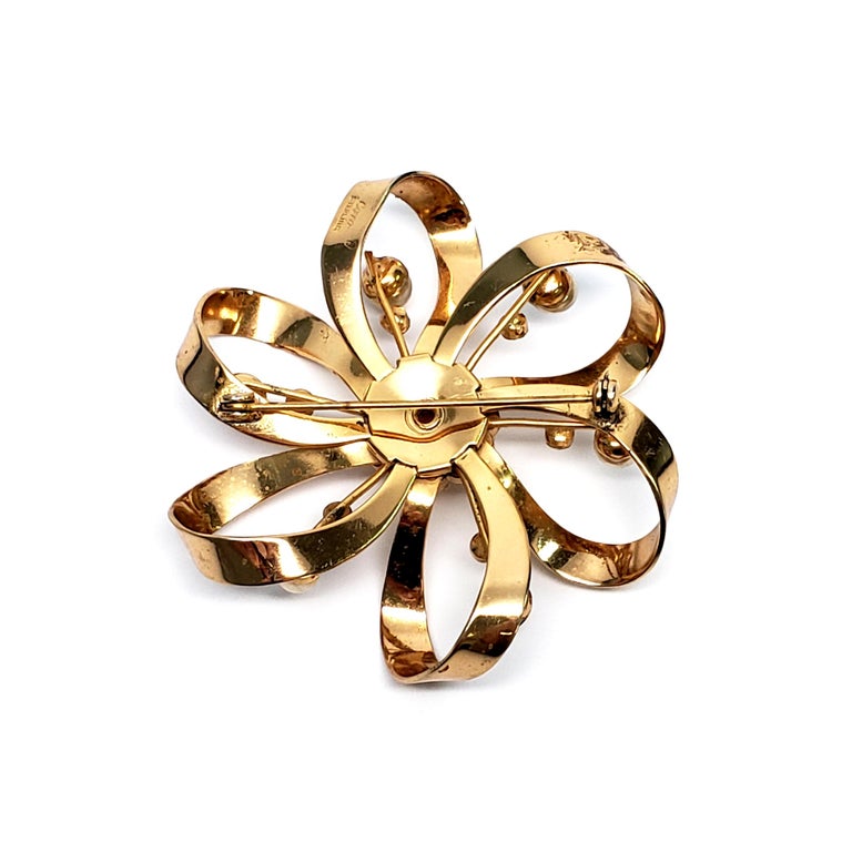 Coro gold vermeil over sterling silver flower pin.

The looped petal design is adorned with gold colored pearls and clear crystals.

Measures 2 1/4