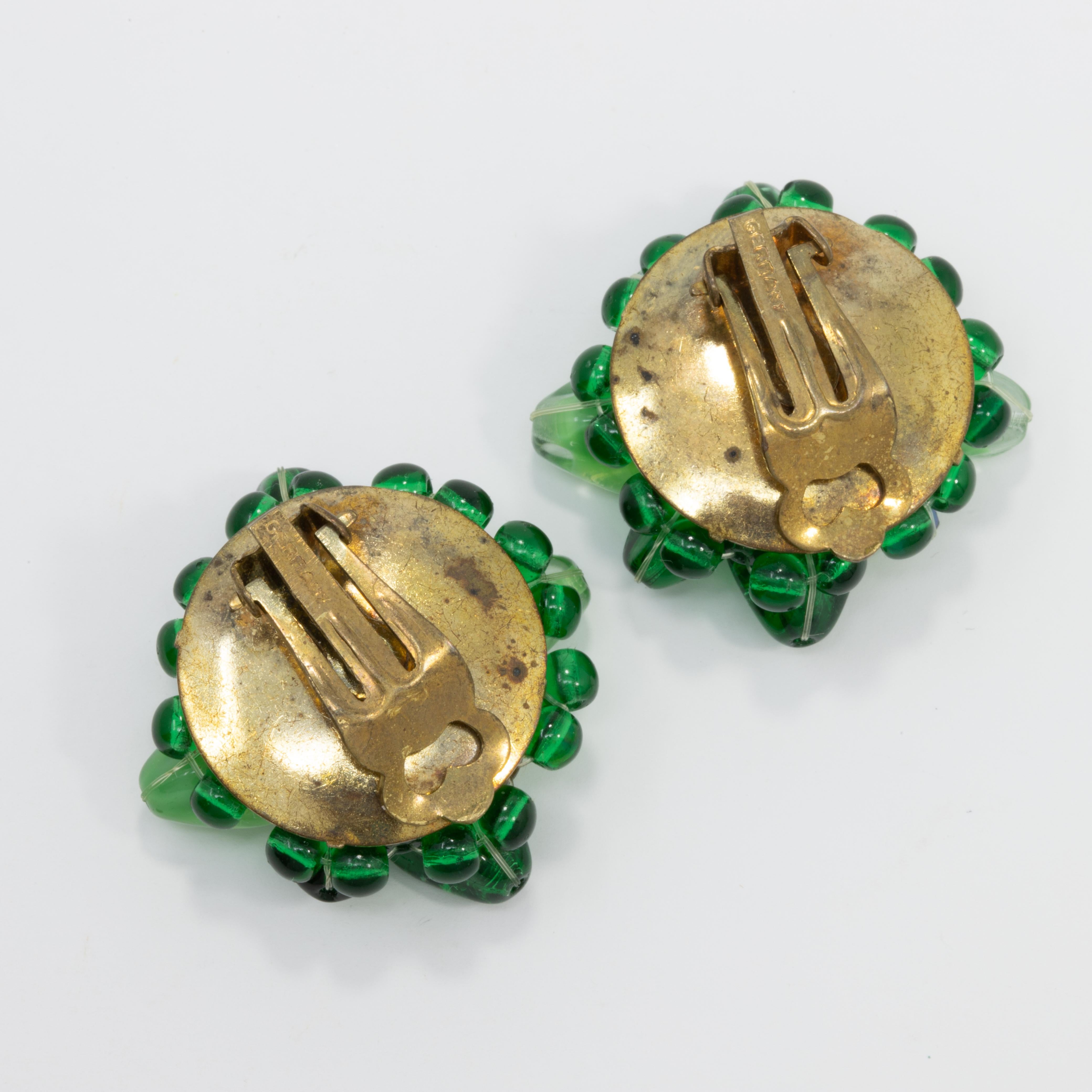 Pair of vintage clip on Coro earrings, each featuring emerald and peridot crystals and a single green faux pearl. Comes with original paper label, marked 