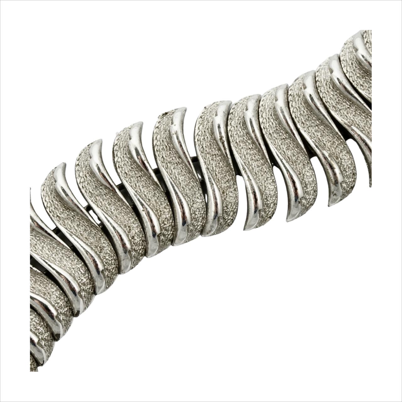 Bracciale a maglie Coro Pegasus placcato argento, testurizzato e lucido, con catena di sicurezza. Misura 18,5 cm di lunghezza per 2,3 cm di larghezza. La placcatura in argento è usurata. 

Questo è un braccialetto dal design molto elegante di Coro.