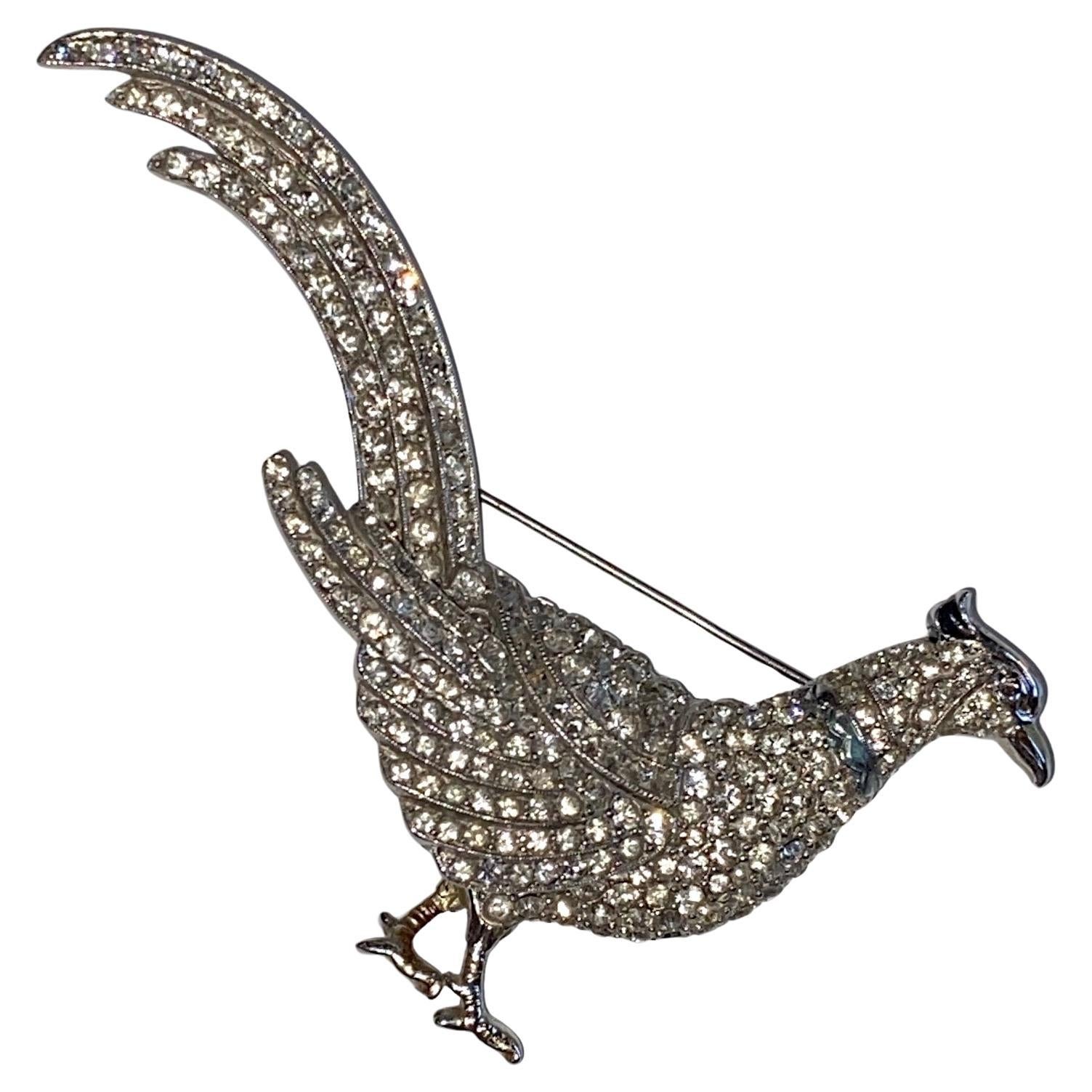 Presented is a beautiful rhinestone encrusted large pheasant brooch designed by Adolph Katz for Coro Inc. The design was patented in 1942. The pheasant is 4 inches long and 2.5 inches tall from the top of the tail to the bottom of the foot. It is