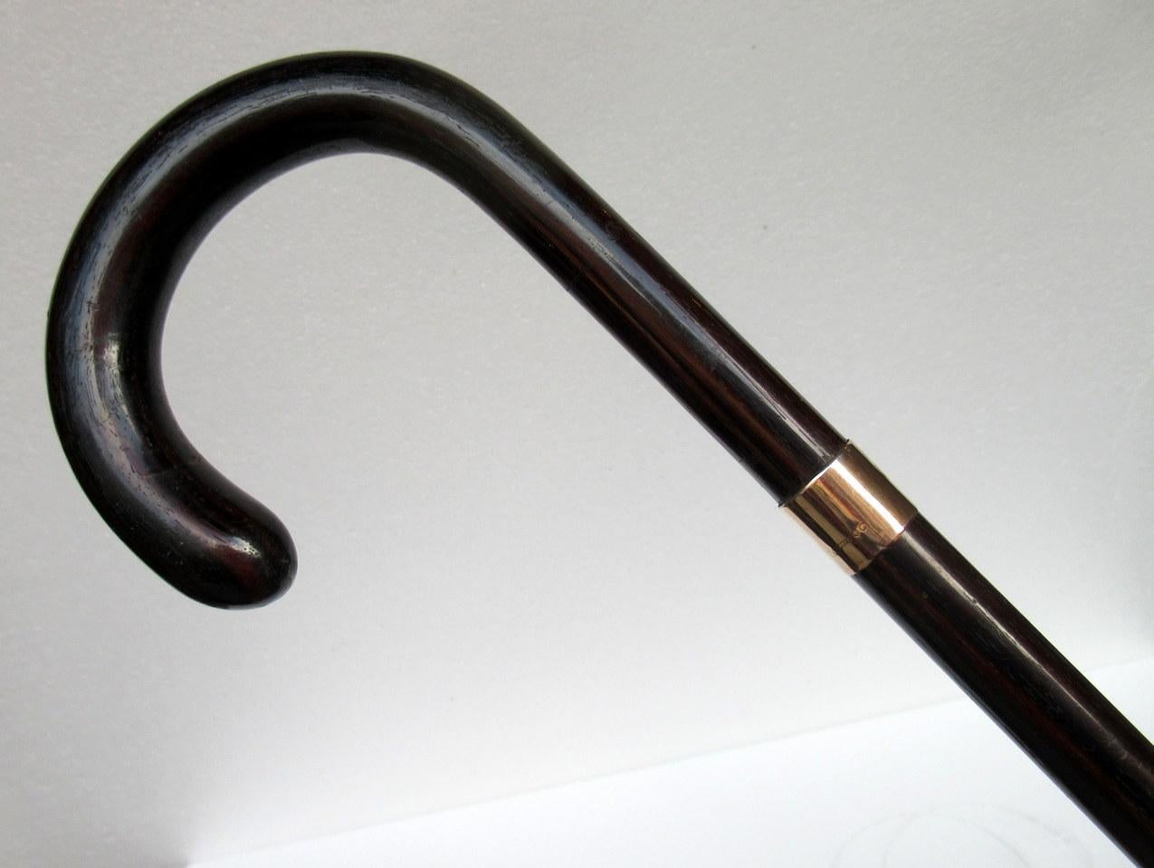 Superb rare polished well grained Coromandel walking cane of outstanding quality, 1924.

The dark well veined crook handle and shaft are made in one piece decorated with a fully hallmarked gold collar and owner’s initials WN, ending on its