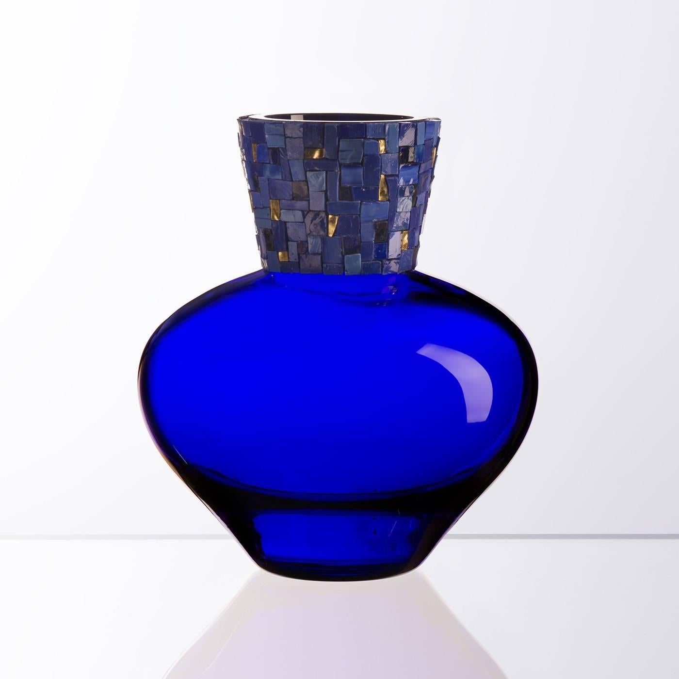 Elegant and unique, this sophisticated Murano mouth-blown glass vase is a perfect accent to enliven any interior design, thanks to the graceful mosaic details that grace its neck. The sinuous body is made of Murano mouth-blown glass in a bold, blue