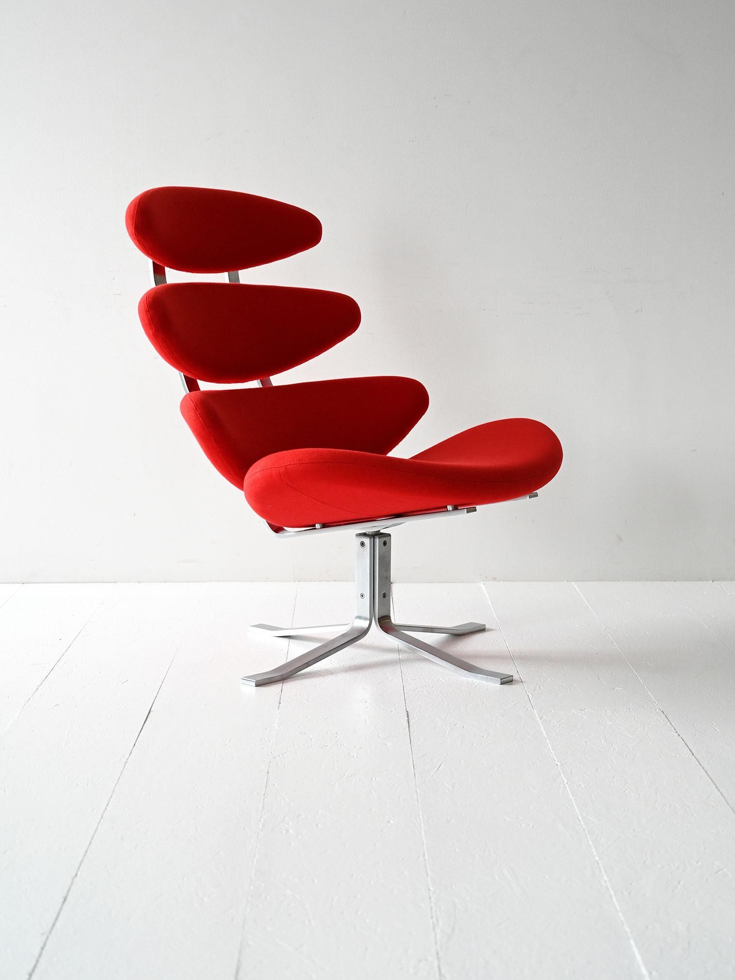 Sillón Corona original de Poul M. Volther para Erik Jørgensen, con estructura de acero y funda de tela roja.

Diseñado en 1961 por Poul M. Volther y fabricado por Erik Jørgensen, este sillón se ha convertido en un icono del diseño danés. El armazón