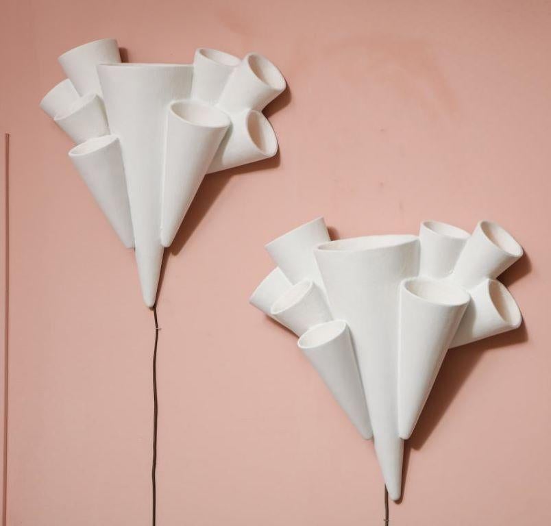 Beautiful pair of plaster sconces formed as a cluster of cones in various sizes. 1 candelabra socket in each of the 9 cones. This model is no longer in production and these sconces are being offered as a secondary market item. Recently rewired with