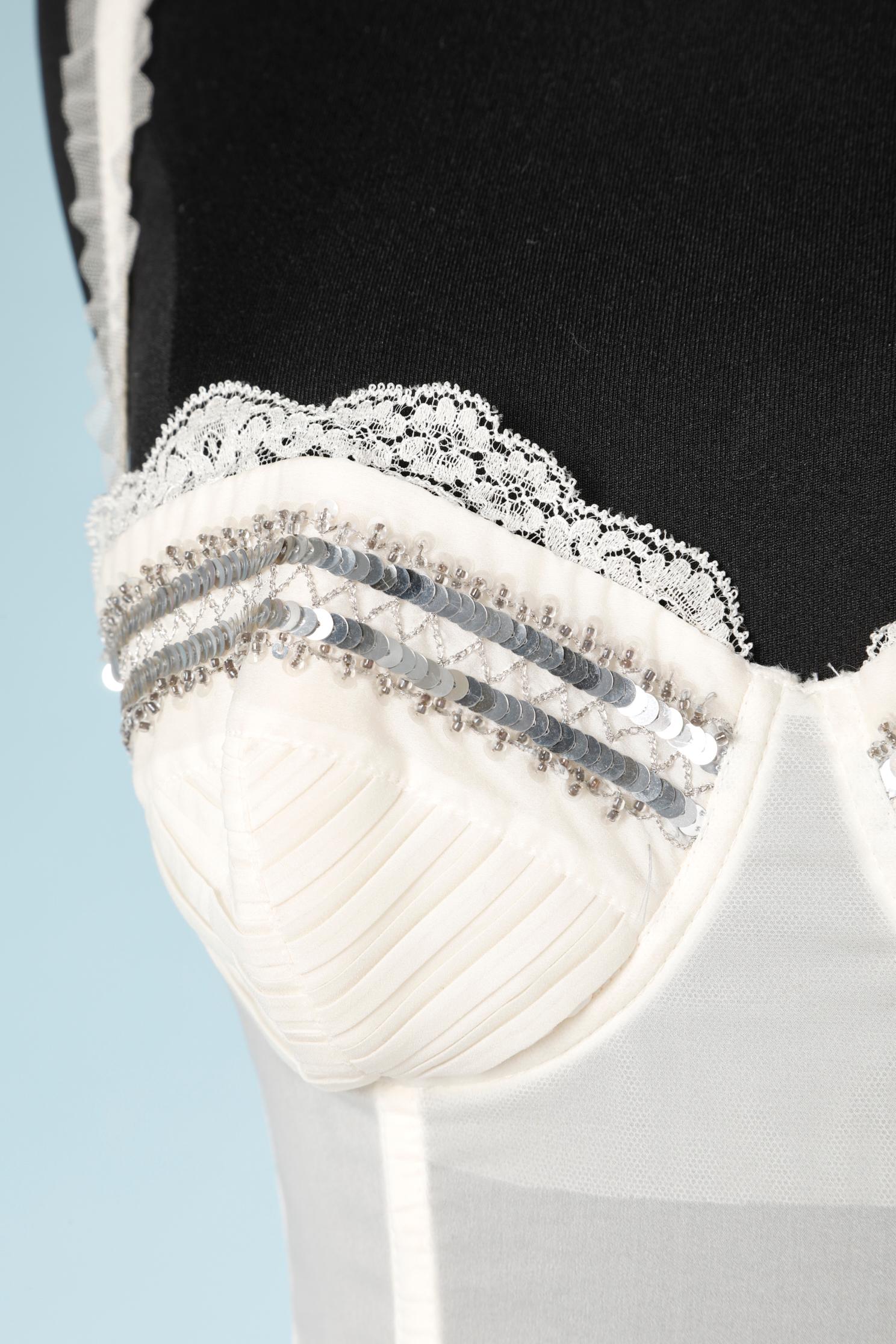 White corset with suspender belt in white silk and polyamide . Silver sequences embroidered and tulle frills.