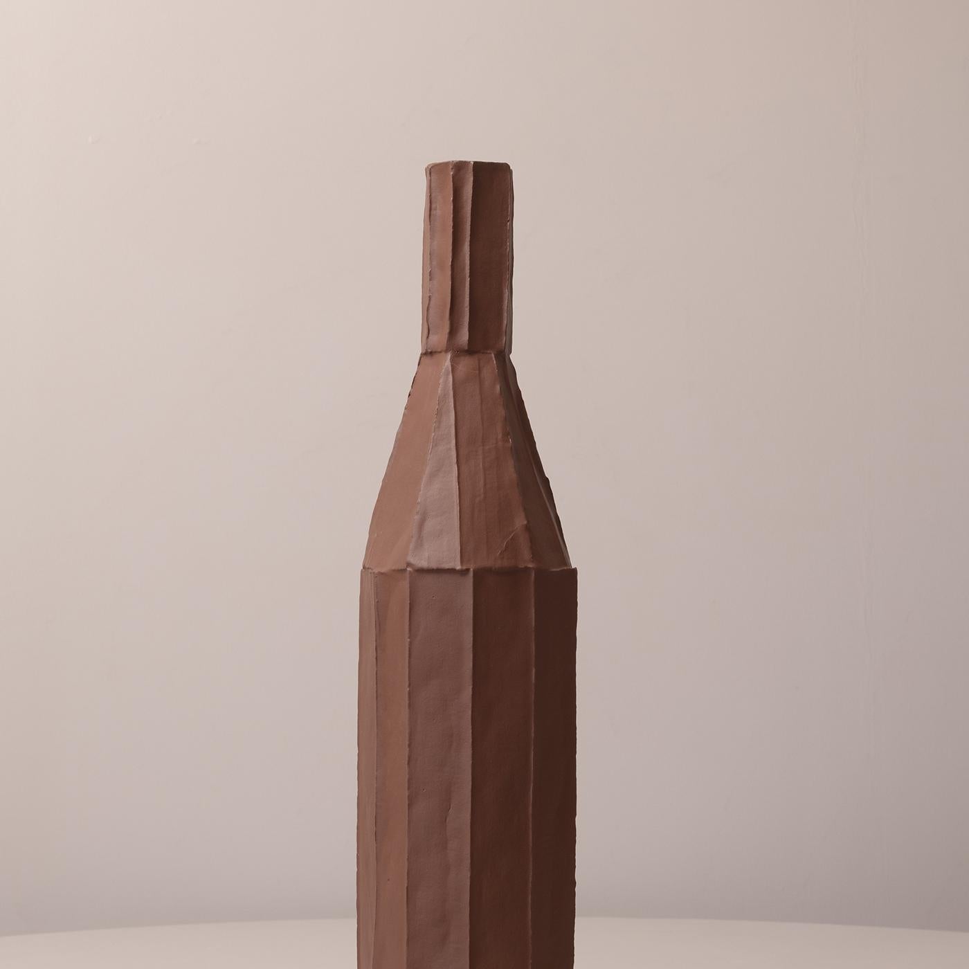 Diese dekorative Flasche zeichnet sich durch eine elegante hohe Silhouette mit einem schlanken, modernen Design aus. Es besteht aus einem einzigartigen MATERIAL, bei dem Fasern in die Tonbasis integriert sind, und bietet faszinierende taktile