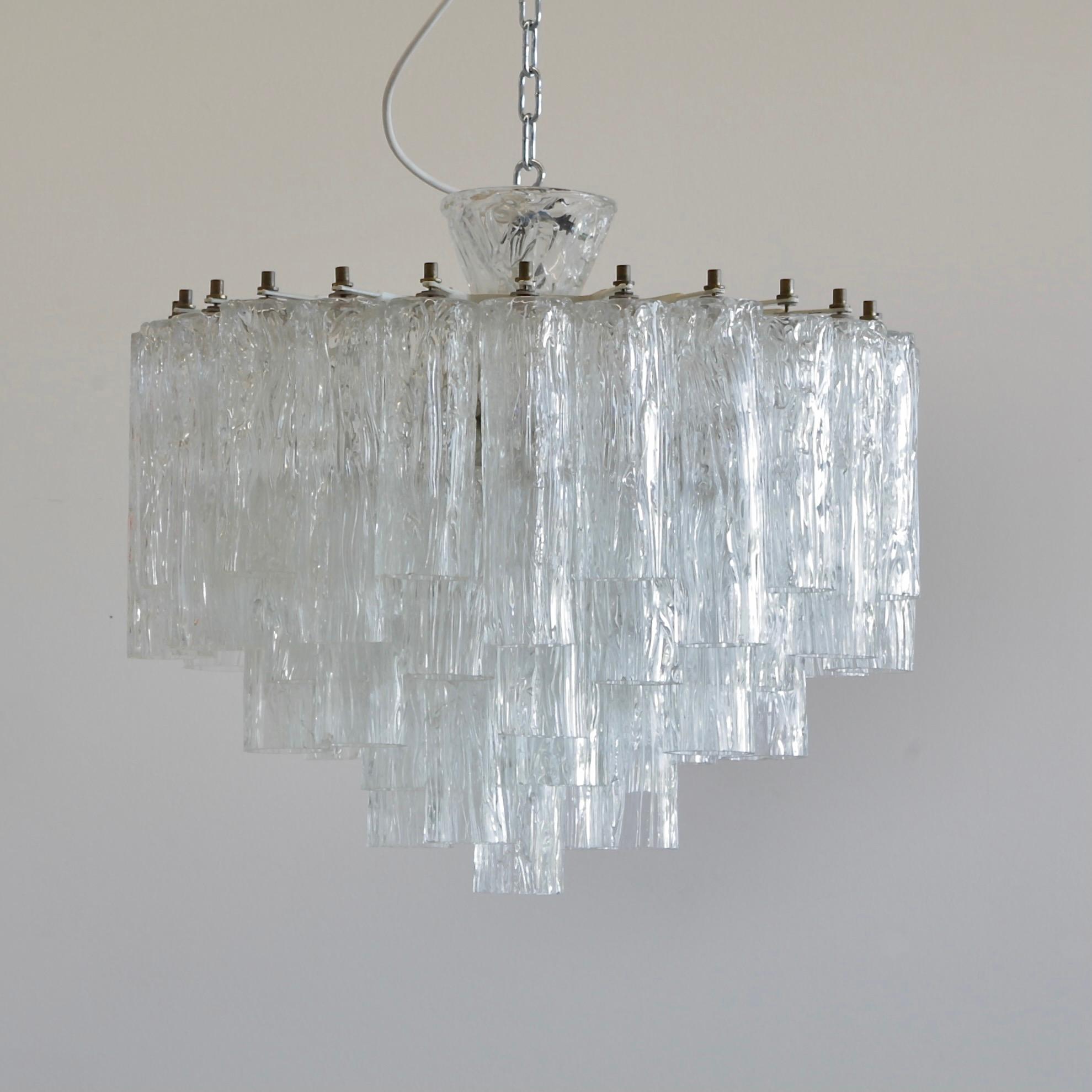 Corteccia' glass chandelier. Italy, Murano, 1960s.

An early glass chandelier with clear glass 'Corteccia' glass made in Murano. Multi-tier glass chandelier with white metal frame, brass detail and a 'Corteccia' glass cup. Super elegant!
 