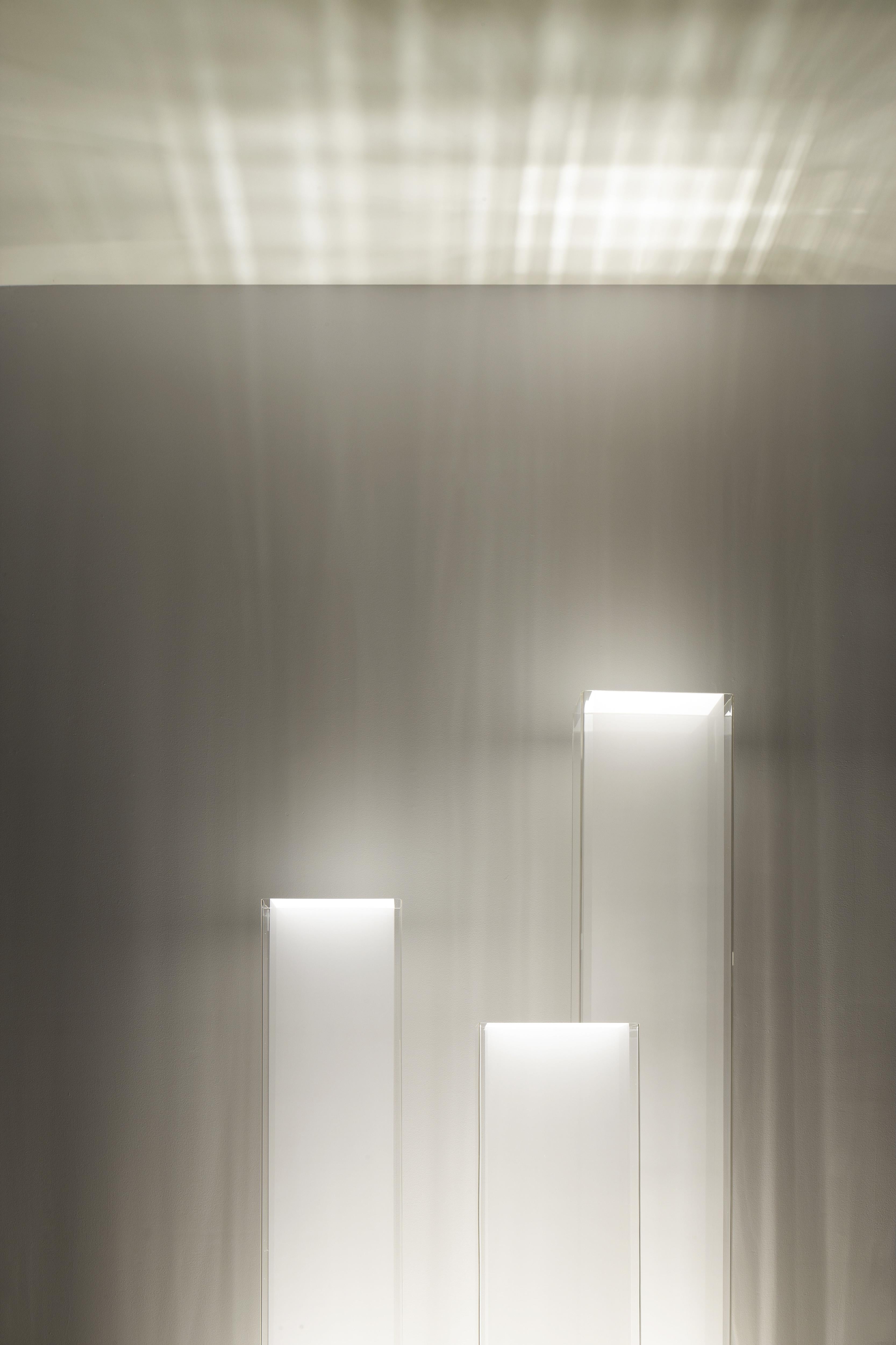 La lampe intemporelle Cortina est d'une simplicité architecturale. Son abat-jour stoïque en acrylique transparent est doté d'un diffuseur sensuel en tissu à mailles translucides qui protège la source lumineuse graduable de la lampe. Cortina vous