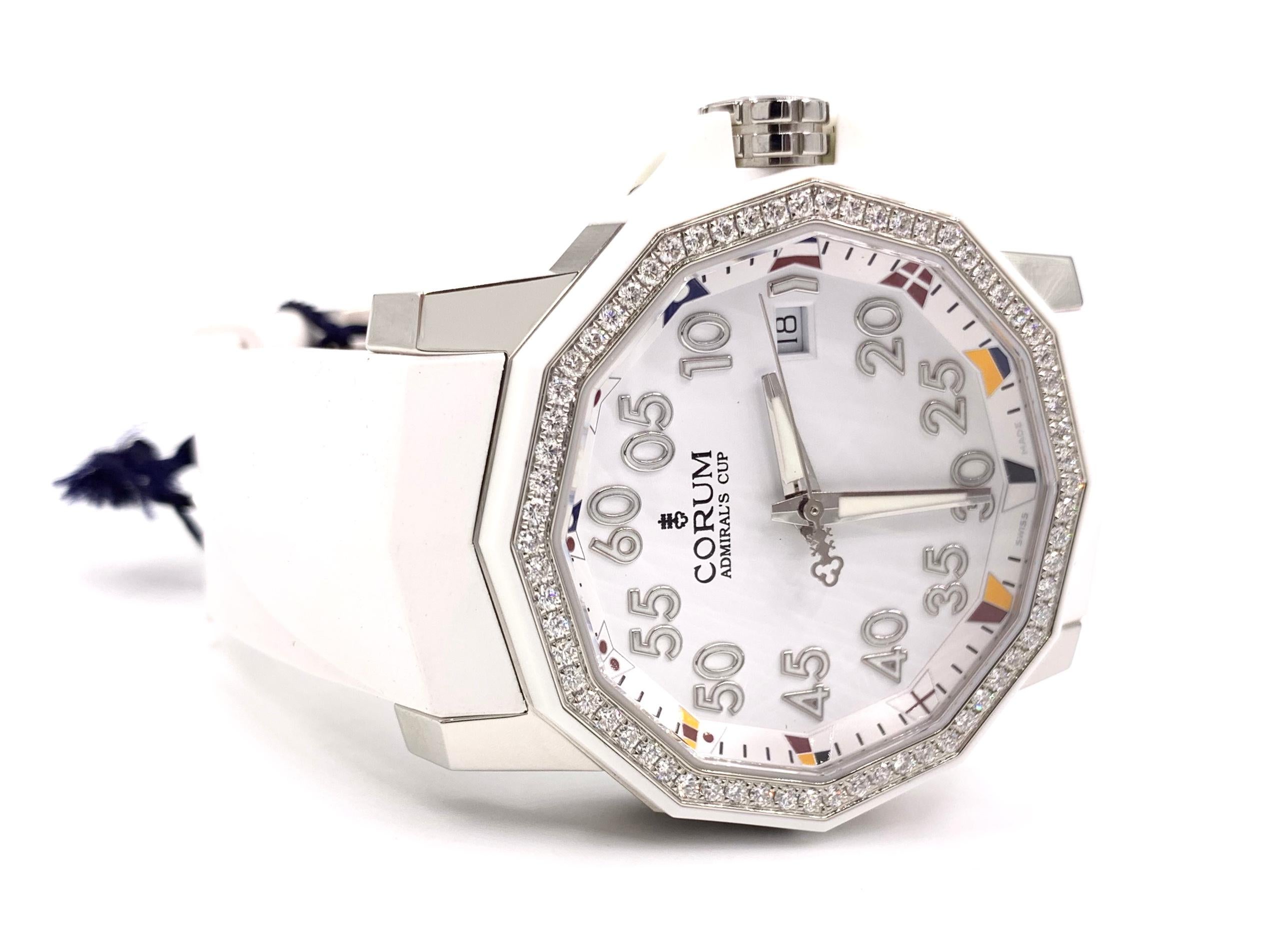 * This piece is not previously-owned * The ultimate summer sport watch with a touch of sparkle, the CORUM Admiral's Cup Competition 40 automatic watch with a diamond bezel on a white rubber strap and deployment clasp closure disguised as a tang