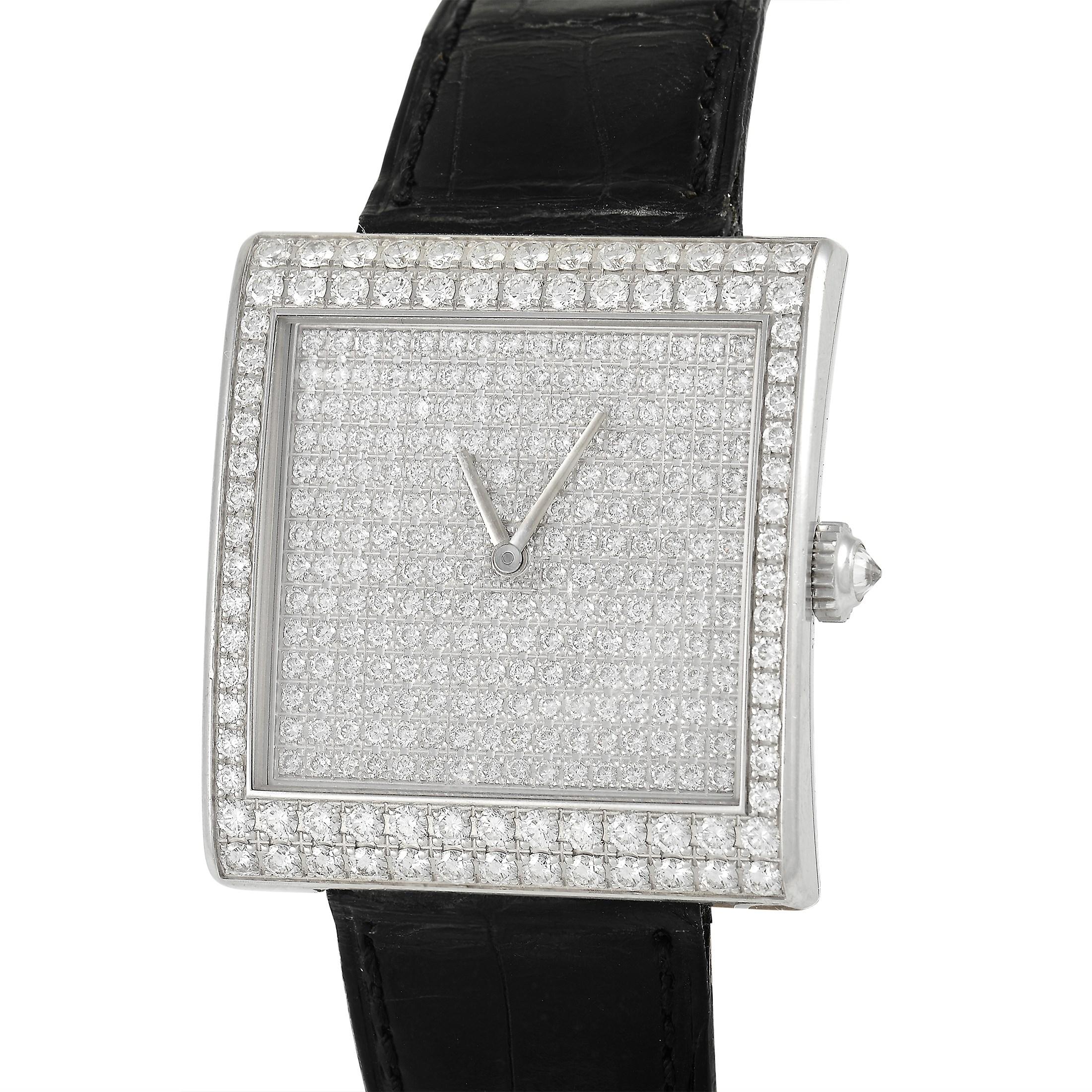 This Corum Buckingham watch, reference number 138.182.69, features an 18K white Gold case that measures 37 x 40mm and is set with round-cut diamonds over the entire face and bezel of the watch. The case is presented on a sleek black leather strap