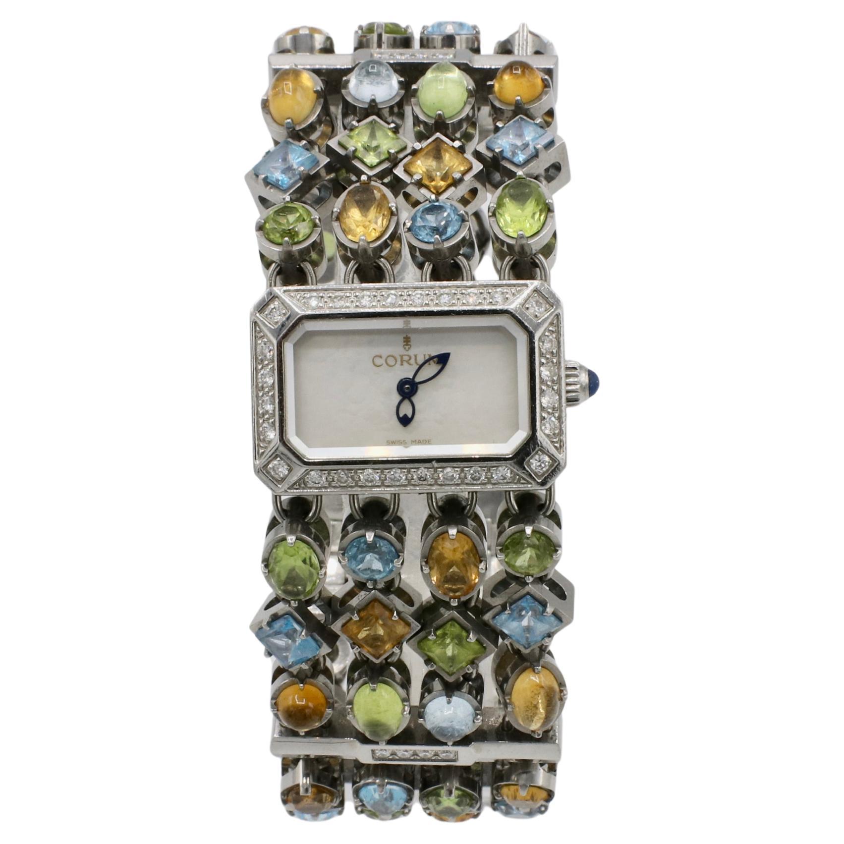 Corum Montre Pot-Pourri Natural Diamond &  Montre pour dames avec pierres de couleur
Référence : 137.520.47
Mouvement : Quartz (fonctionne bien)
Métal : Acier inoxydable
Taille du poignet : S'adapte à un poignet de 6,25 pouces au maximum.
Largeur :