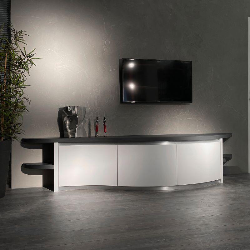 Modern sideboard, in shades of white and gray. Thanks to the sinuous shape and the absence of edges, it fits perfectly even in small spaces. Is possible to place a television, either on the shelf of the furniture or hung on the wall. Cool white