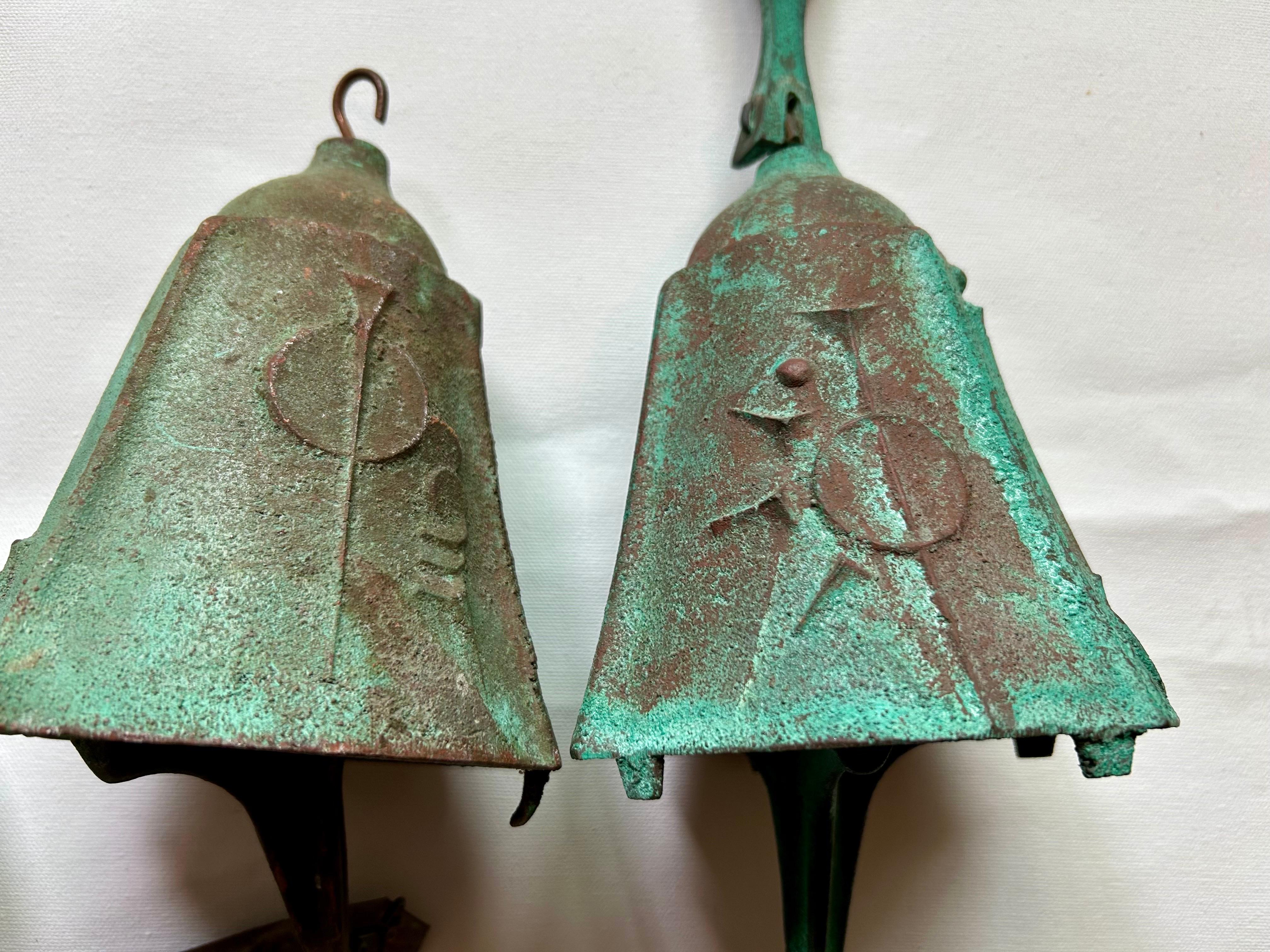 Nice set of bronze bells with a wonderful verdigris patina.
No two are exactly alike.
Made at the Arcosanti bronze factory in Arizona.
They have a nice musical sound.
One is missing the hanging arm. It can be easily hung with a chain.  
Great for