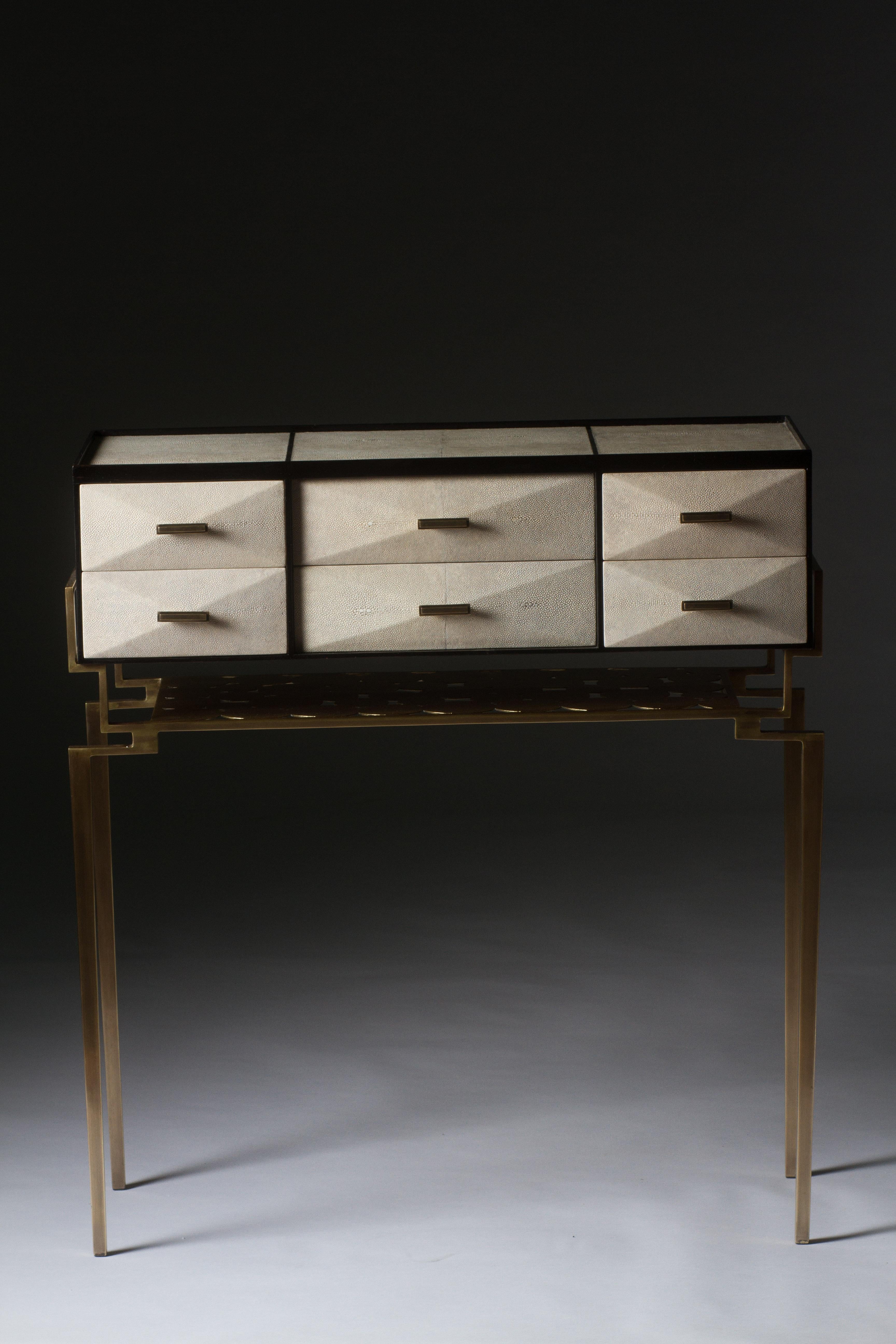 The Cosima 7 console, is both practical and stunning in design. This smaller console includes 6 beveled geometric drawers that can used to store anything from jewelry to stationary. This piece includes a bronze-patina brass shelf below the drawers