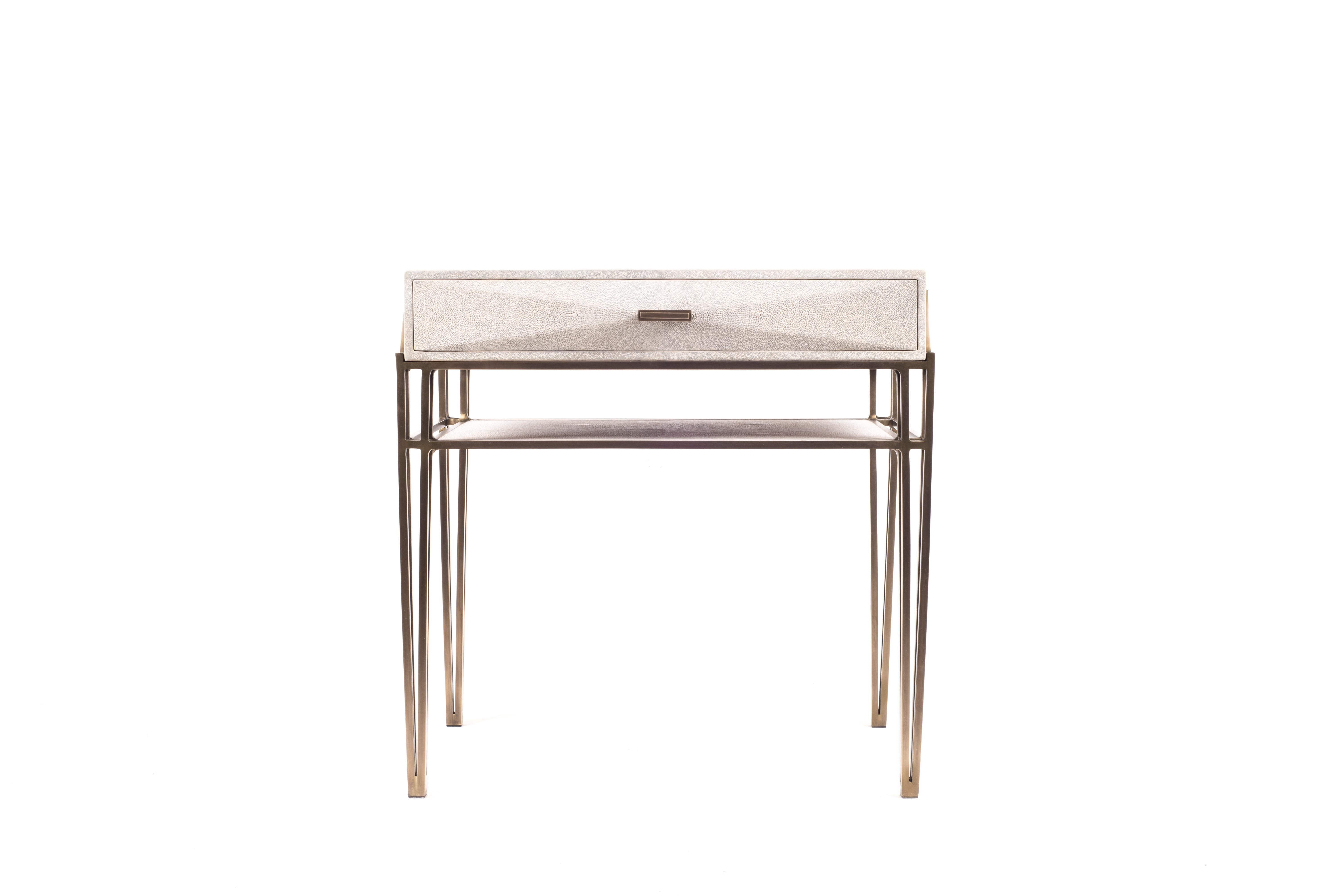 The Cosima bedside table, is both practical and stunning in design. This bedside table is the perfect accent piece for any intimate space. This table has one large drawer, and the top piece in cream shagreen can be removed from the bronze-patina