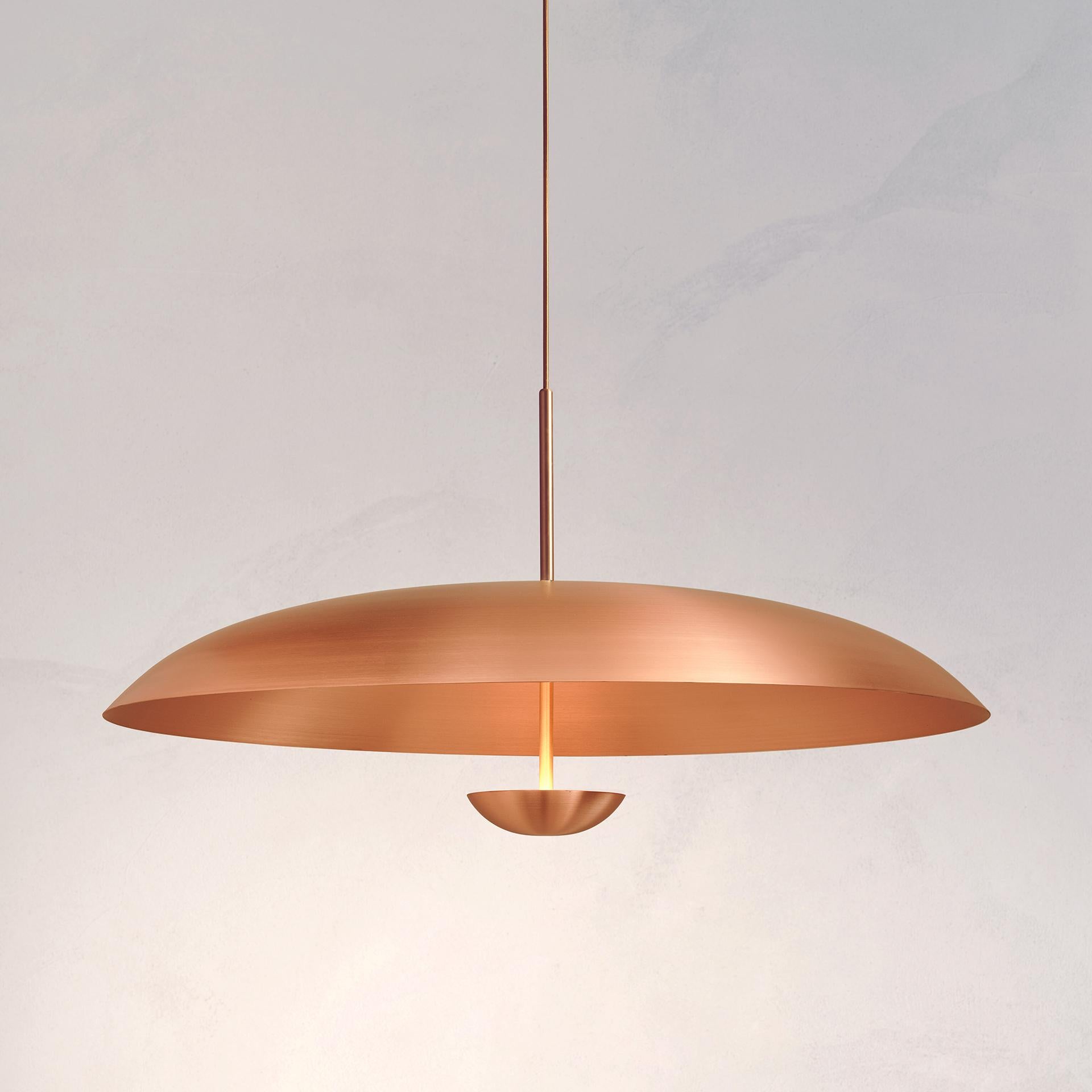 Two finely hand-spun copper plates make up this pendant light,  creating this unique appearance. The light is projected into the shade and reflects out, illuminating without creating a glare.
 
This light fixture is suitable for both contemporary
