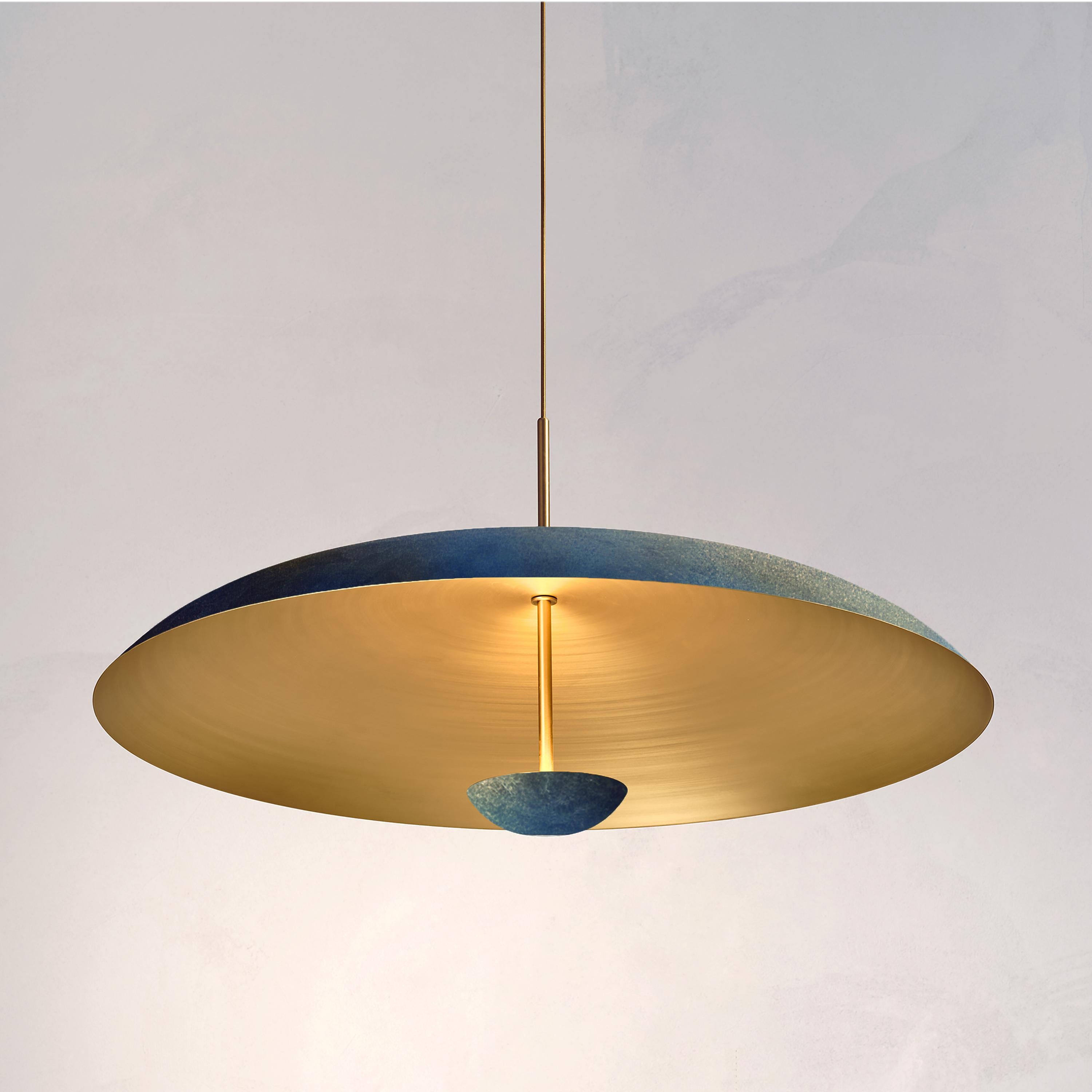 Two finely hand-spun brass plates make up this pendant light, finished in a custom 'Azure' patina to create this unique appearance. The light is projected into the shade and reflects out, illuminating without creating a glare.
 
This light fixture