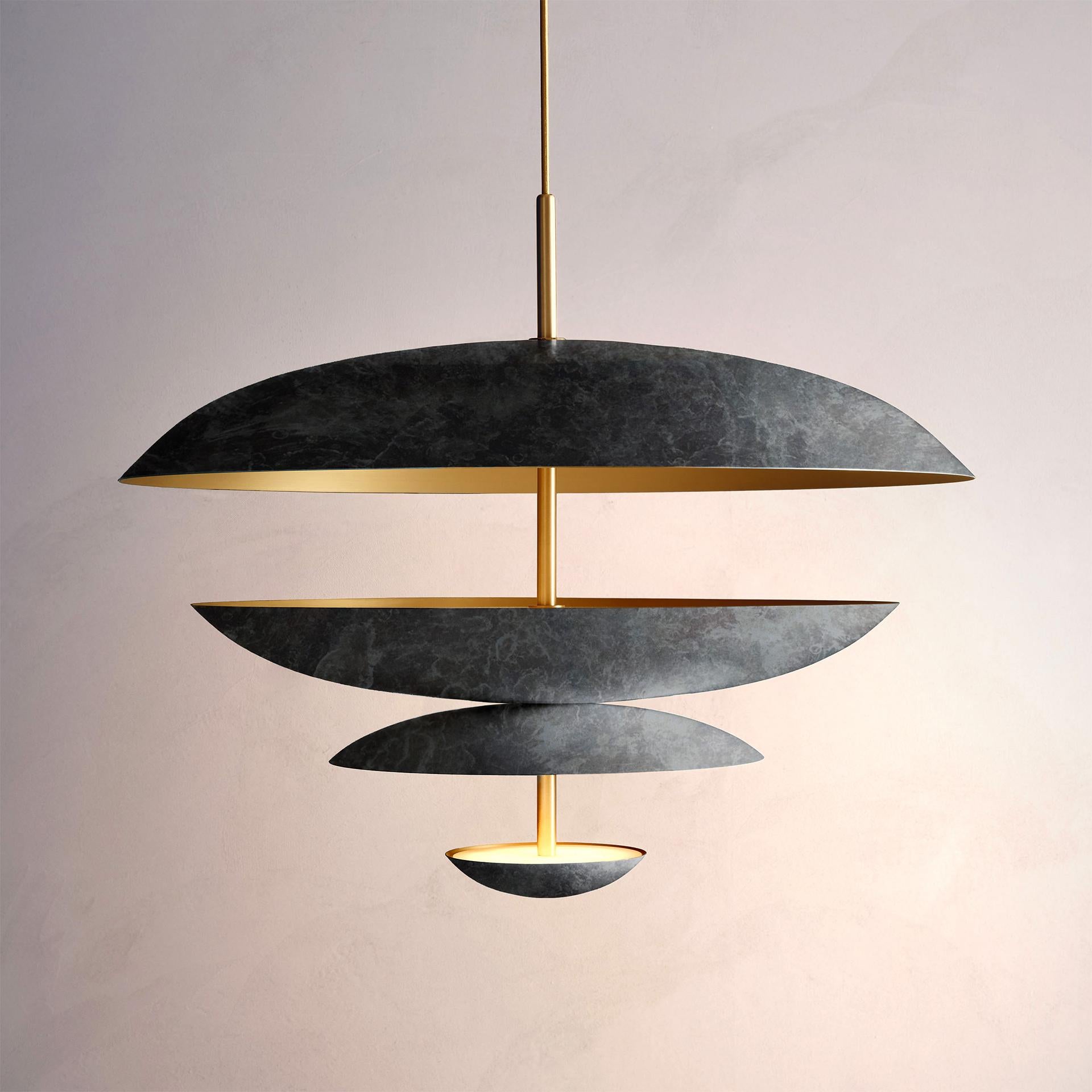 Composed by four finely hand-spun brass plates, this chandelier is finished in a callisto patina on one side and satin brushed brass on the other to reveal the bright texture of brass. Light is projected into the shade before reflecting out,