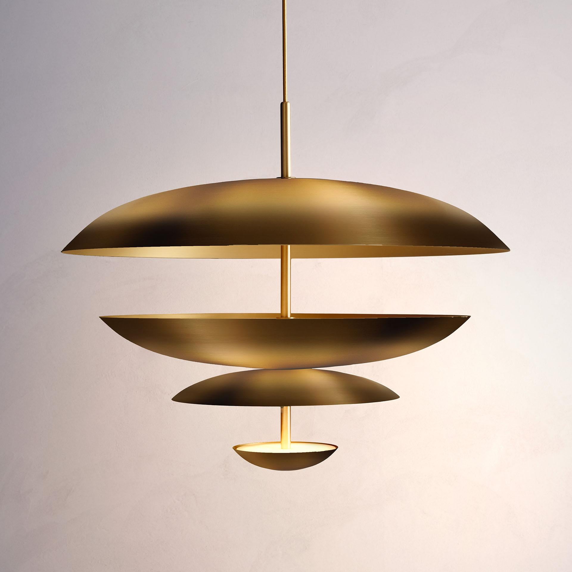 Inspired by planet-like shapes and textures, the Cosmic collection plays with both metal properties and a selection of patina finishes. Composed of four carefully hand-spun brass plates, our Ore Chandelier is finished with a mixed patina to create