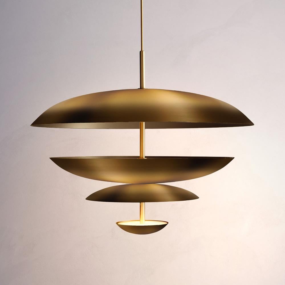 Inspired by planet-like shapes and textures, the Cosmic collection plays with both metal properties and a selection of patina finishes. Composed of four carefully hand-spun brass plates, our Ore Chandelier is finished with a mixed patina to create
