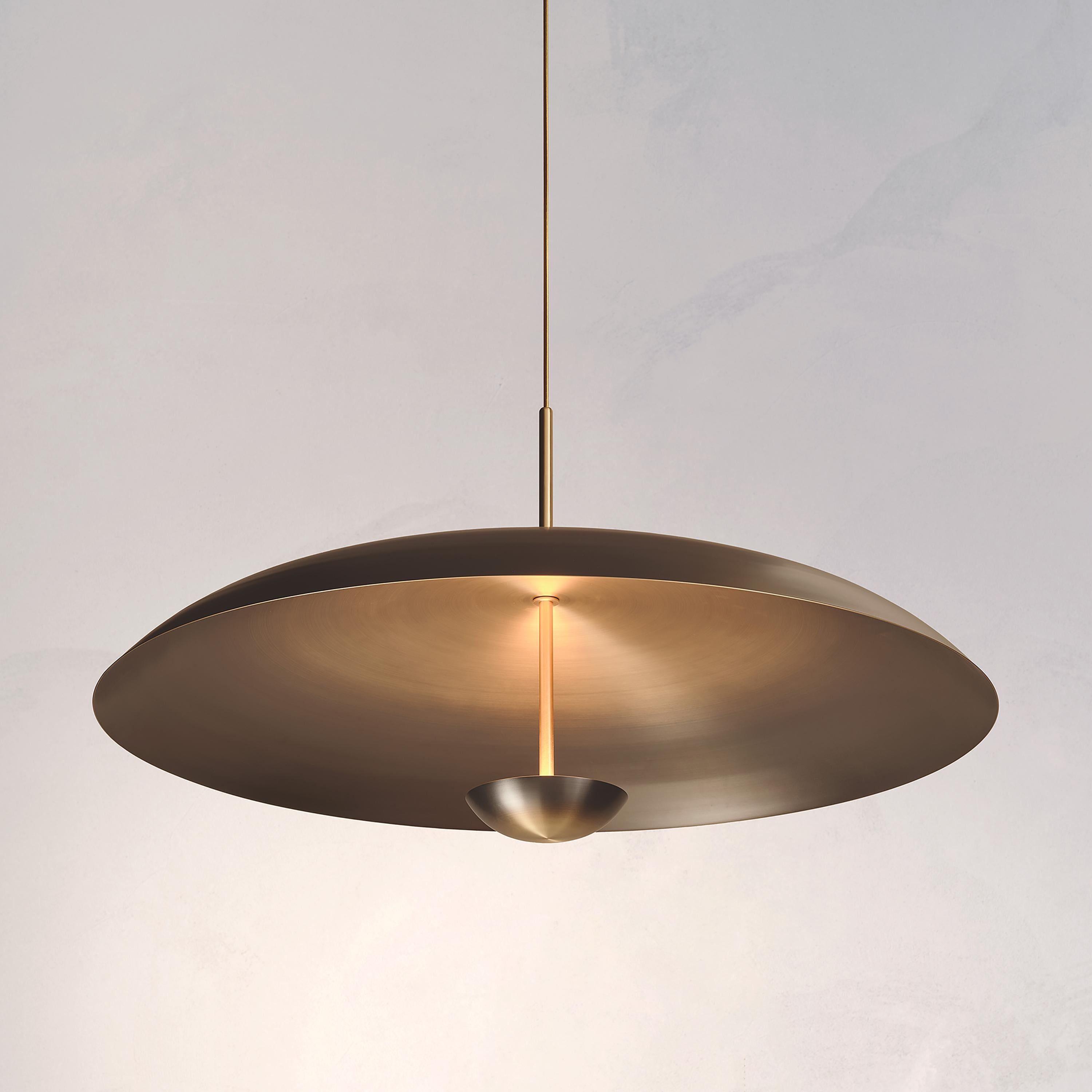 Two finely hand-spun brass plates make up this pendant light, a bronze to brass gradient accentuates the shape. The light is projected into the shade and reflects out, illuminating without creating a glare.

This light fixture is suitable for both