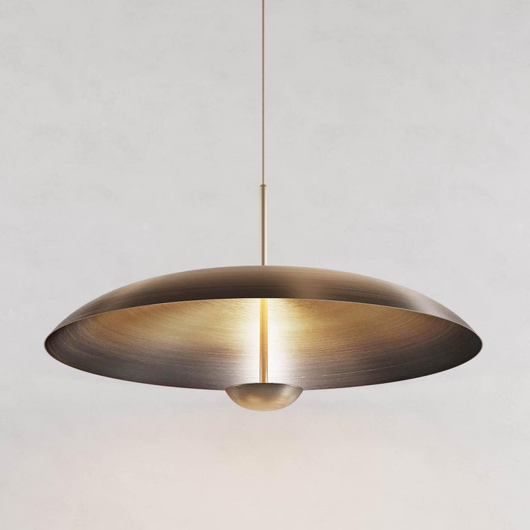 Two finely hand-spun brass plates make up this pendant light, a bronze to brass gradient accentuates the shape. The light is projected into the shade and reflects out, illuminating without creating a glare.

This light fixture is suitable for both