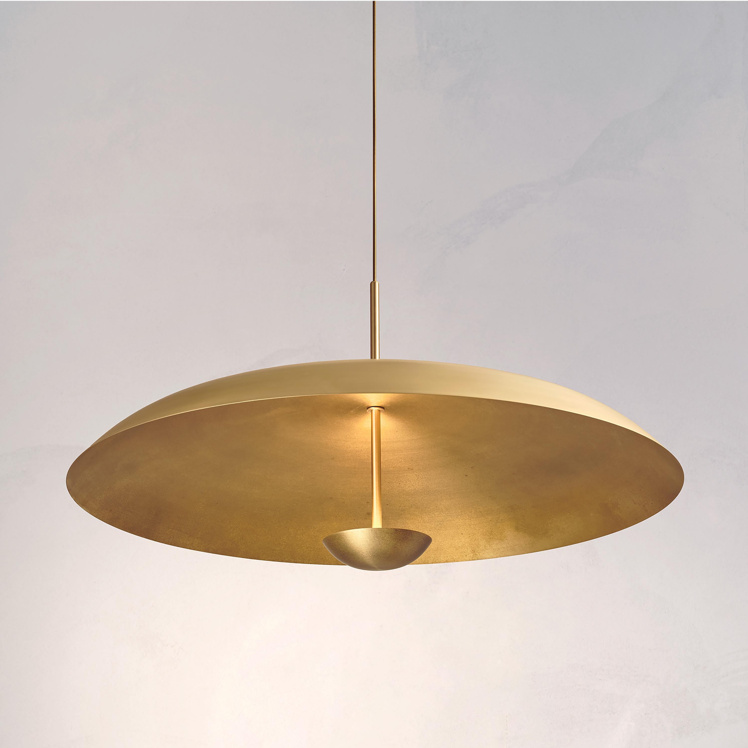 Two finely hand-spun brass plates make up this pendant light, finished in a mixed patina to create this unique appearance. The light is projected into the shade and reflects out, illuminating without creating a glare.
 
This light fixture is