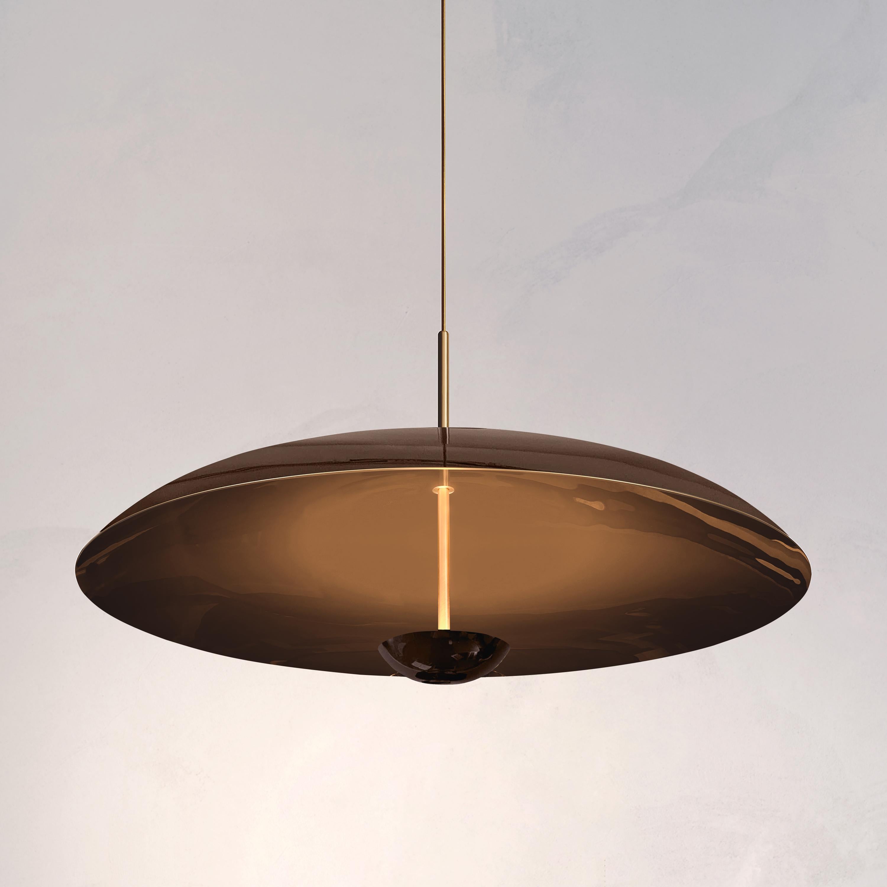 Inspired by planet-like forms and textures, the Cosmic collection explores the interplay between metal and a selection of double-sided, piano-lacquered finishes.
 
Two finely lacquered brass plates make up this pendant light. The light is projected