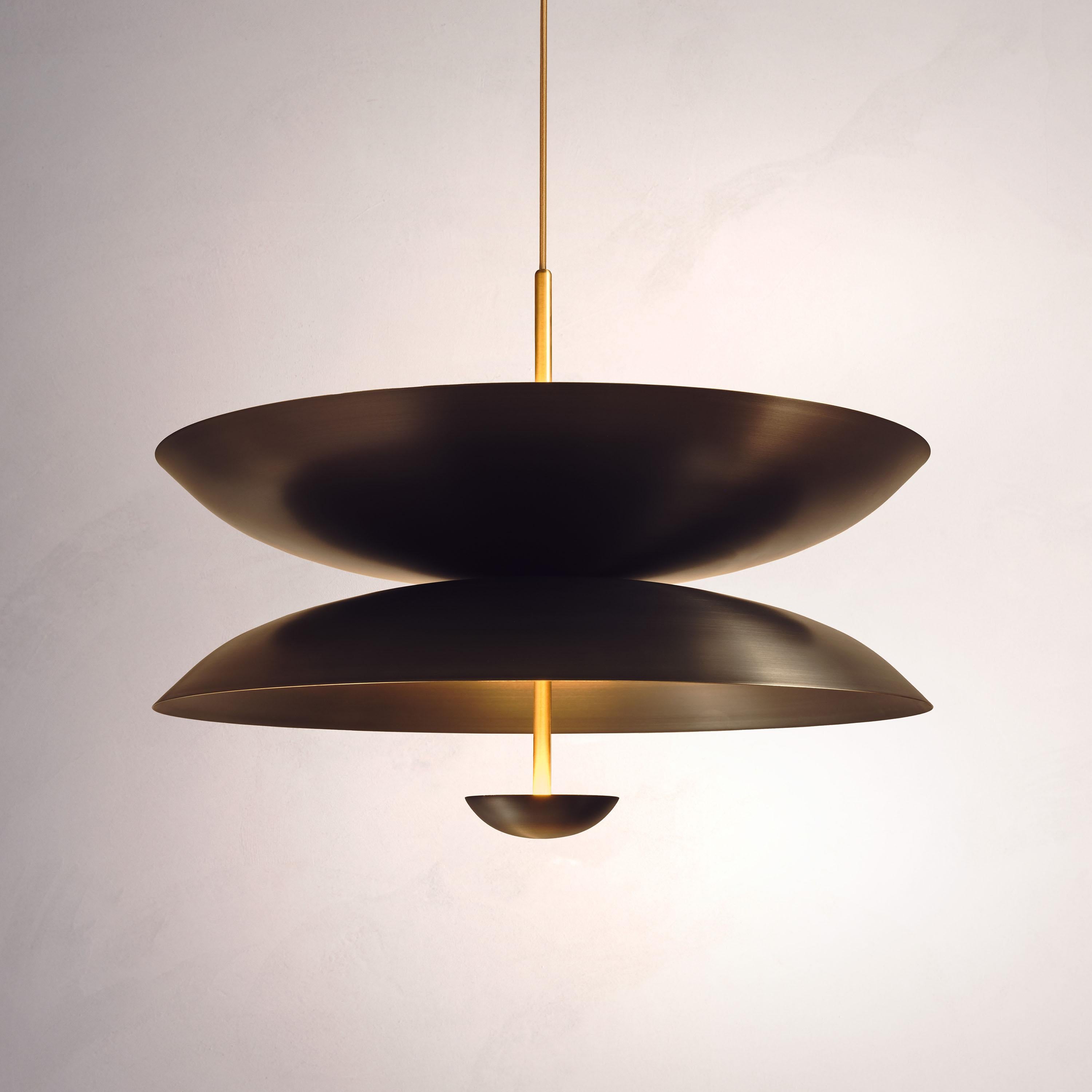 Inspired by planet-like shapes and textures, the Cosmic collection plays with both metal properties and a selection of patina finishes.
 
The Regolith Pendant is composed of two carefully hand-spun brass plates and finished in a mixed patina. One