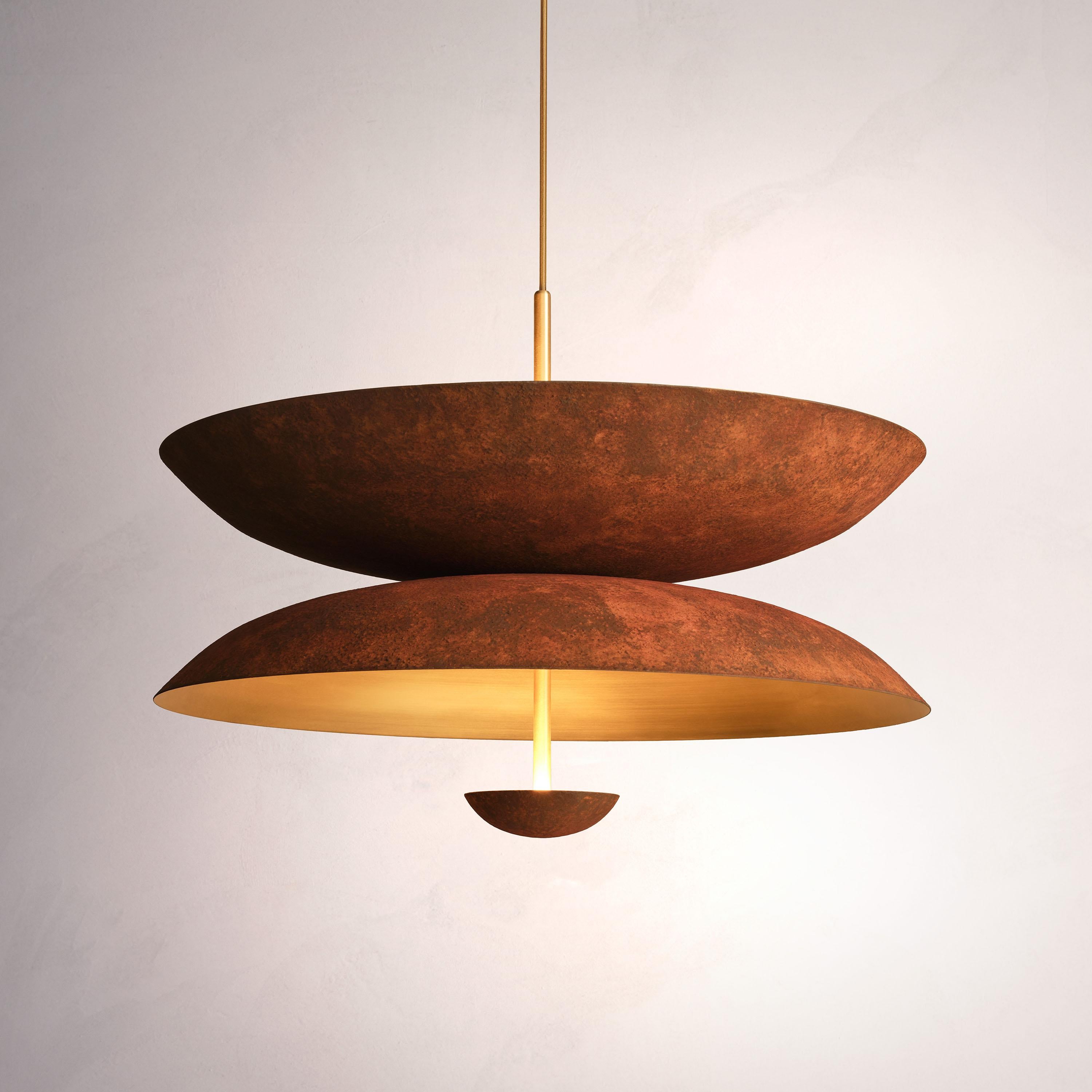 Inspired by planet-like shapes and textures, the Cosmic collection plays with both metal properties and a selection of patina finishes.
 
The Pendant Duo Rust is composed of three carefully hand-spun brass plates and preserves the beautiful texture