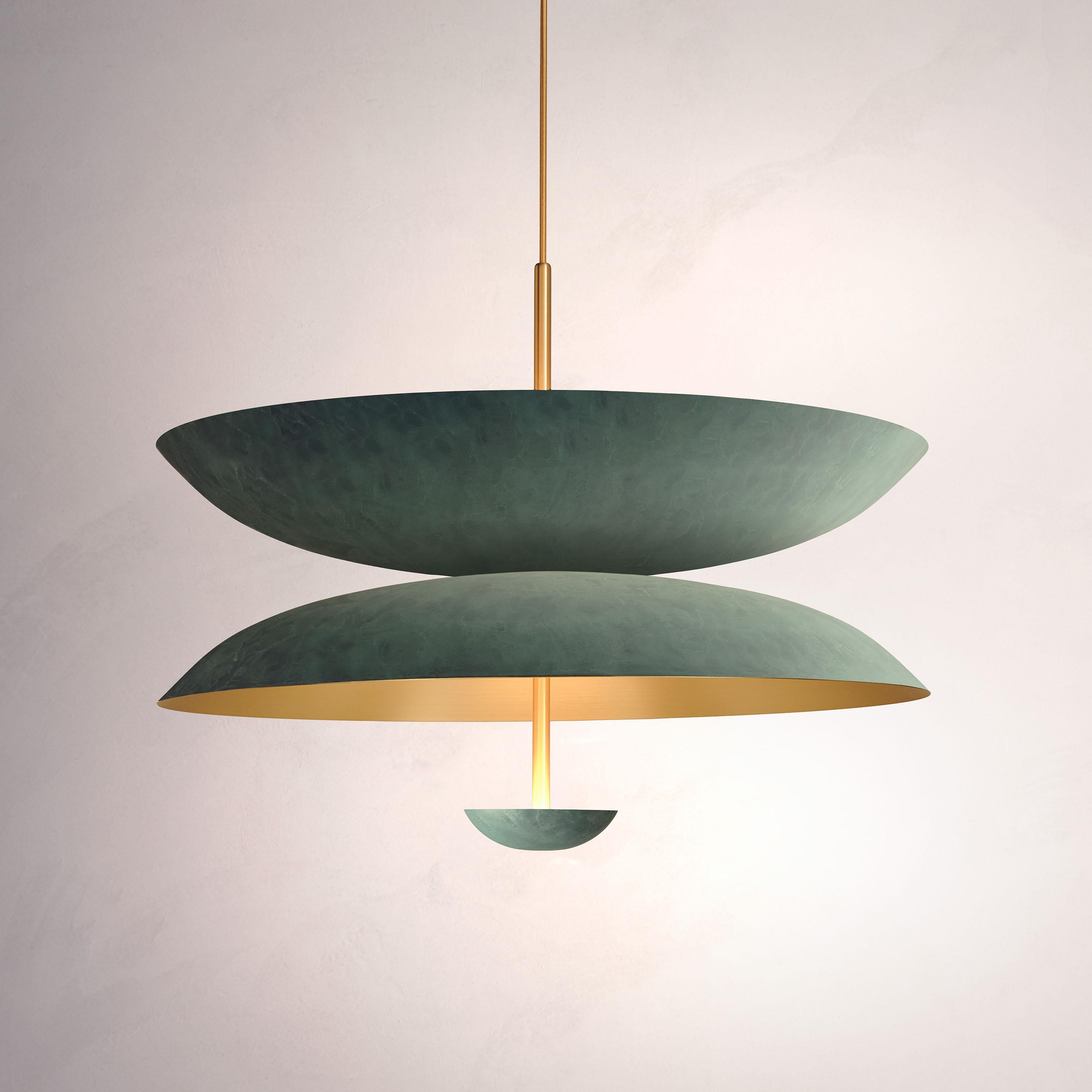 Inspired by planet-like shapes and textures, the Cosmic collection plays with both metal properties and a selection of patina finishes.
 
The Pendant Duo Verdigris is composed of three carefully hand-spun brass plates and preserves the beautiful
