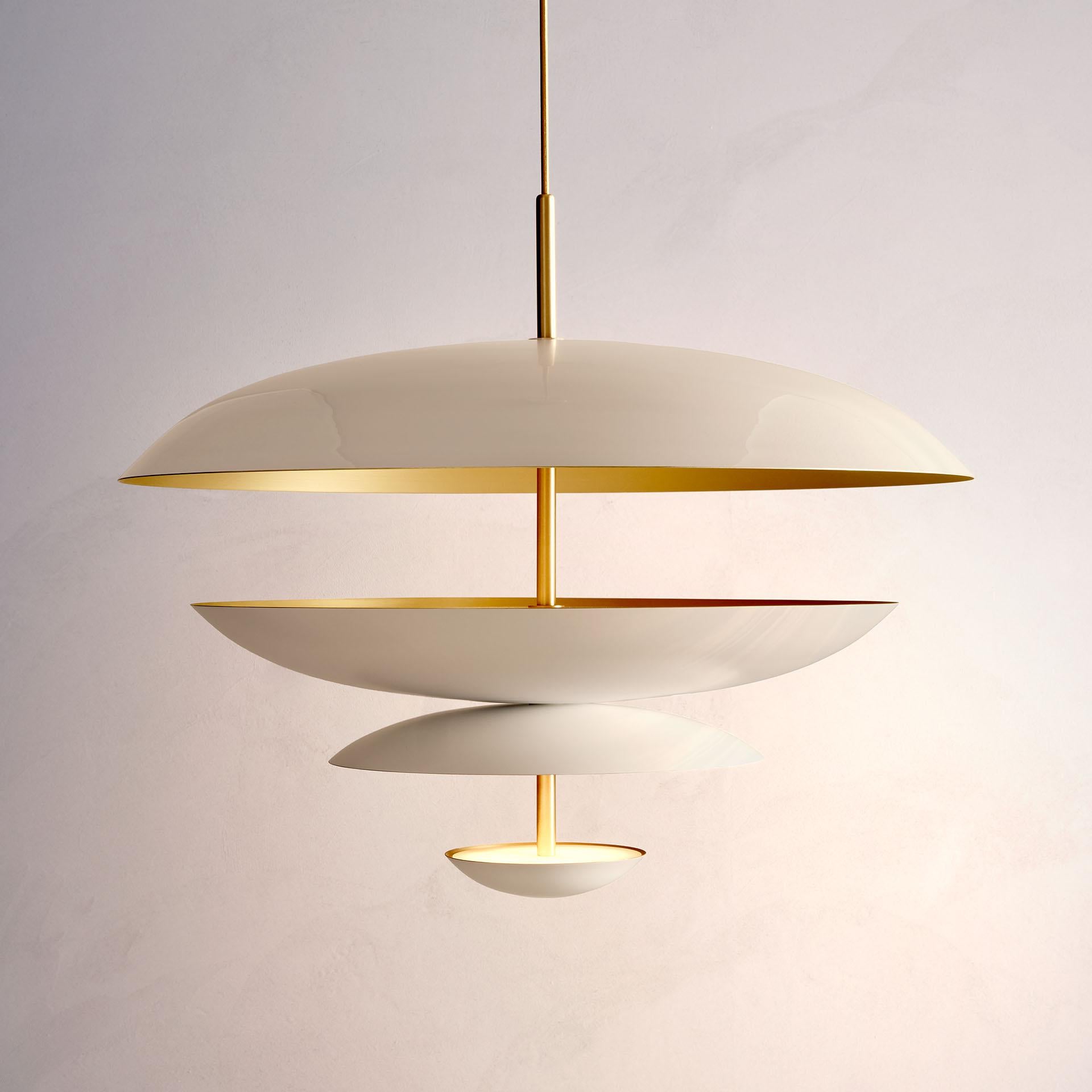 Composed by four finely hand-spun brass plates, this chandelier is finished in a callisto patina on one side and satin brushed brass on the other to reveal the bright texture of brass. Light is projected into the shade before reflecting out,