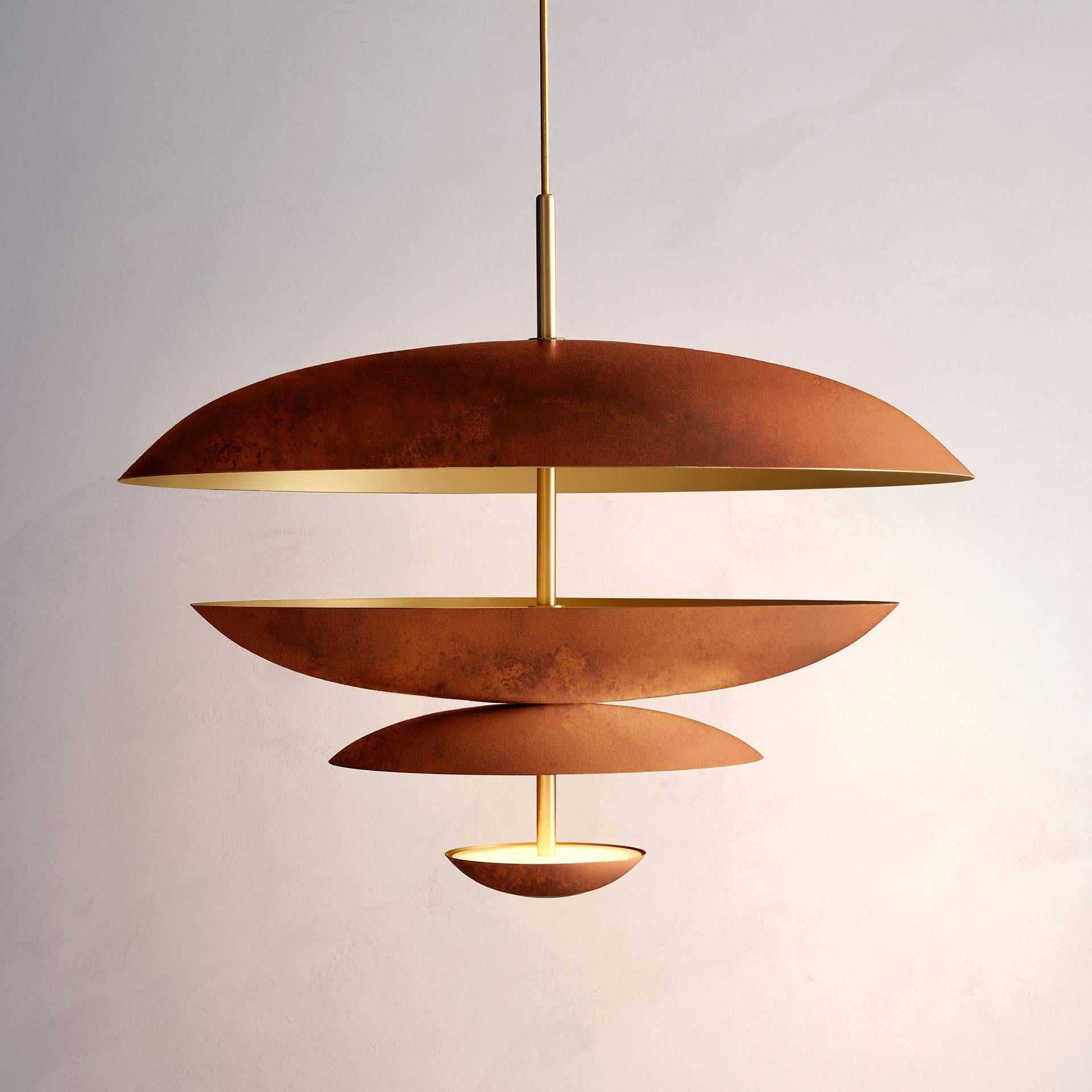 Composed by four finely hand-spun brass plates, this chandelier is finished in a rust patina on one side and satin brushed brass on the other to reveal the bright texture of brass. 

This light fixture is suitable for both contemporary and vintage