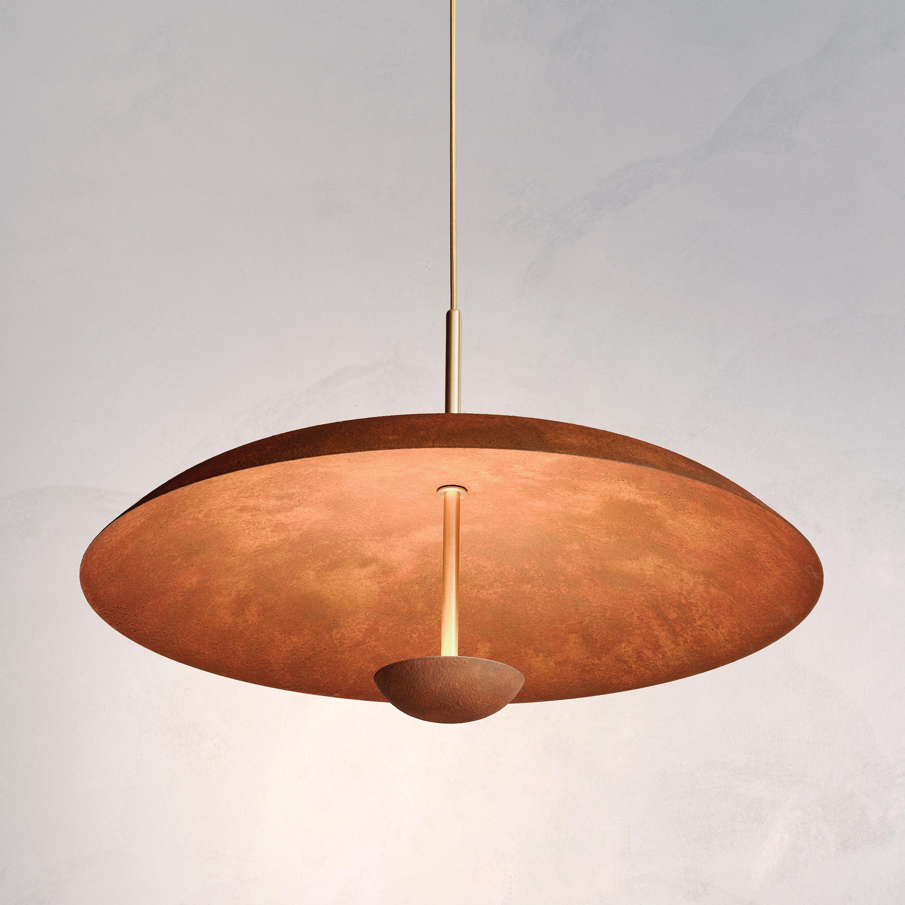 Two finely hand-spun brass plates make up this pendant light, finished in a mixed rust patina to create this unique appearance. The light is projected into the shade and reflects out, illuminating without creating a glare.
 
This light fixture is