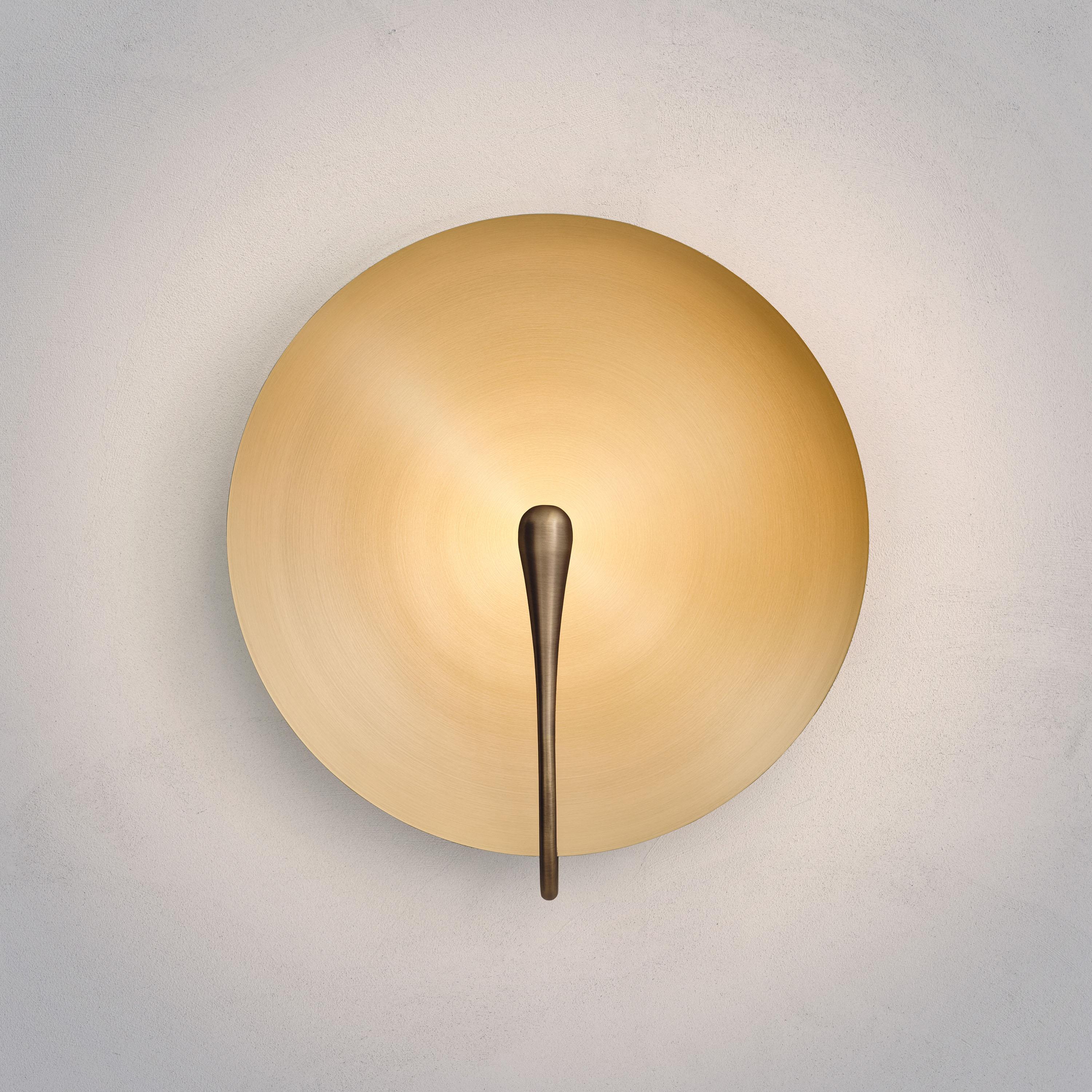 A gentle silhouette of a plate makes up this unique wall light. To create this metalic finish, a brushed finish is applied on a hand-spun brass plate.
 
Softly illuminated with integrated LED from within, this sculptural wall piece sits elegantly in