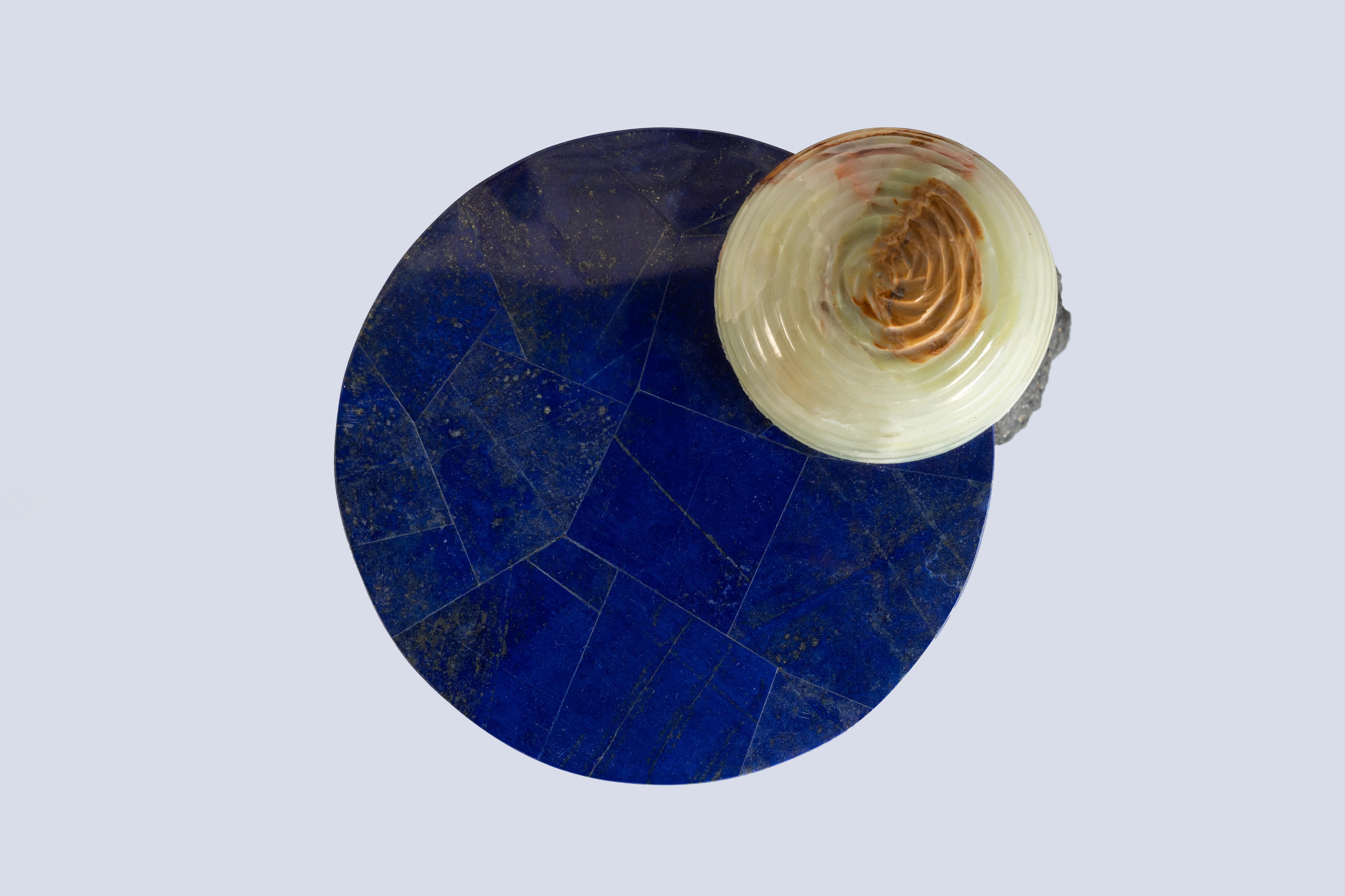 Materials: Red travertine, lava stone, green onyx and Lapislazuli
Hand crafted Side table
Limited edition of 15

Inspired by the enduring legacy of observing the cosmos, 'Cosmic Traces' evolves from the essence of 'Cosmic Relics.' While totems