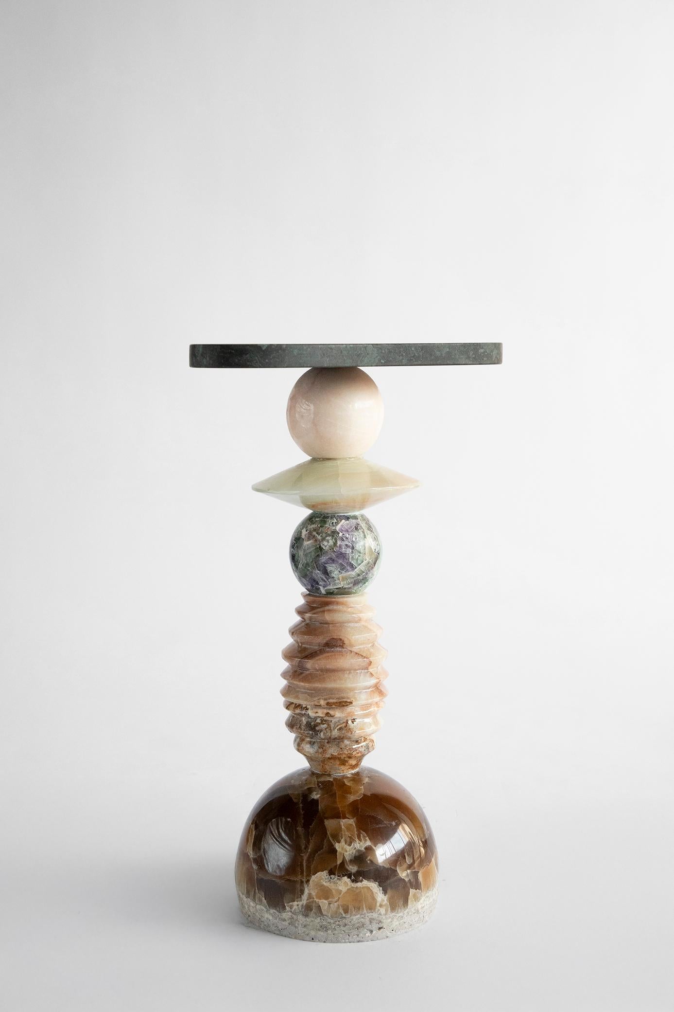Materials: Coca-Cola onyx, amber onyx, fluorite, olive green onyx, pink onyx, green Tikal marble.
Hand crafted Side table
For indoors

Inspired by the enduring legacy of observing the cosmos, 'Cosmic Traces' evolves from the essence of 'Cosmic