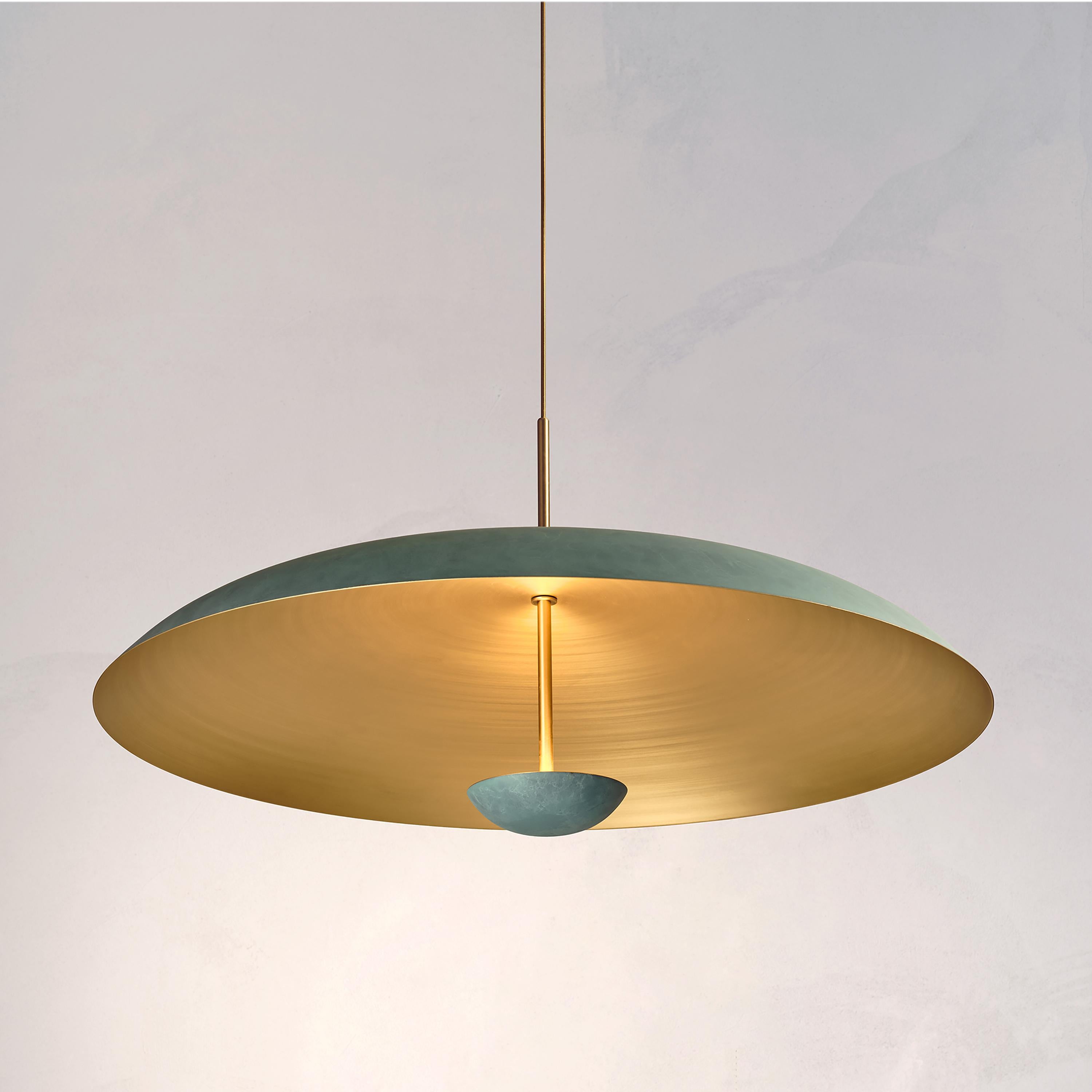 Two finely hand-spun brass plates make up this pendant light, finished in a mixed verdigris patina to create this unique appearance. The light is projected into the shade and reflects out, illuminating without creating a glare.
 
This light fixture