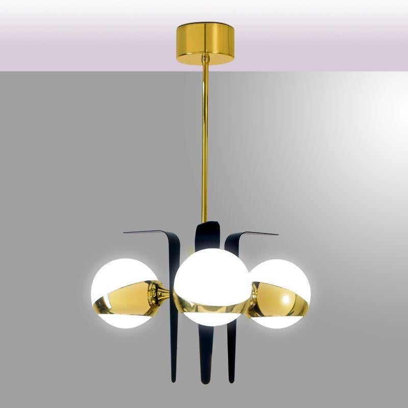 A splendid statement piece for a contemporary interior space of both private and contract nature, this gorgeous pendant lamp will strike the attention of anyone entering the room. Fashioned of brass combining gold and black lacquers, it features