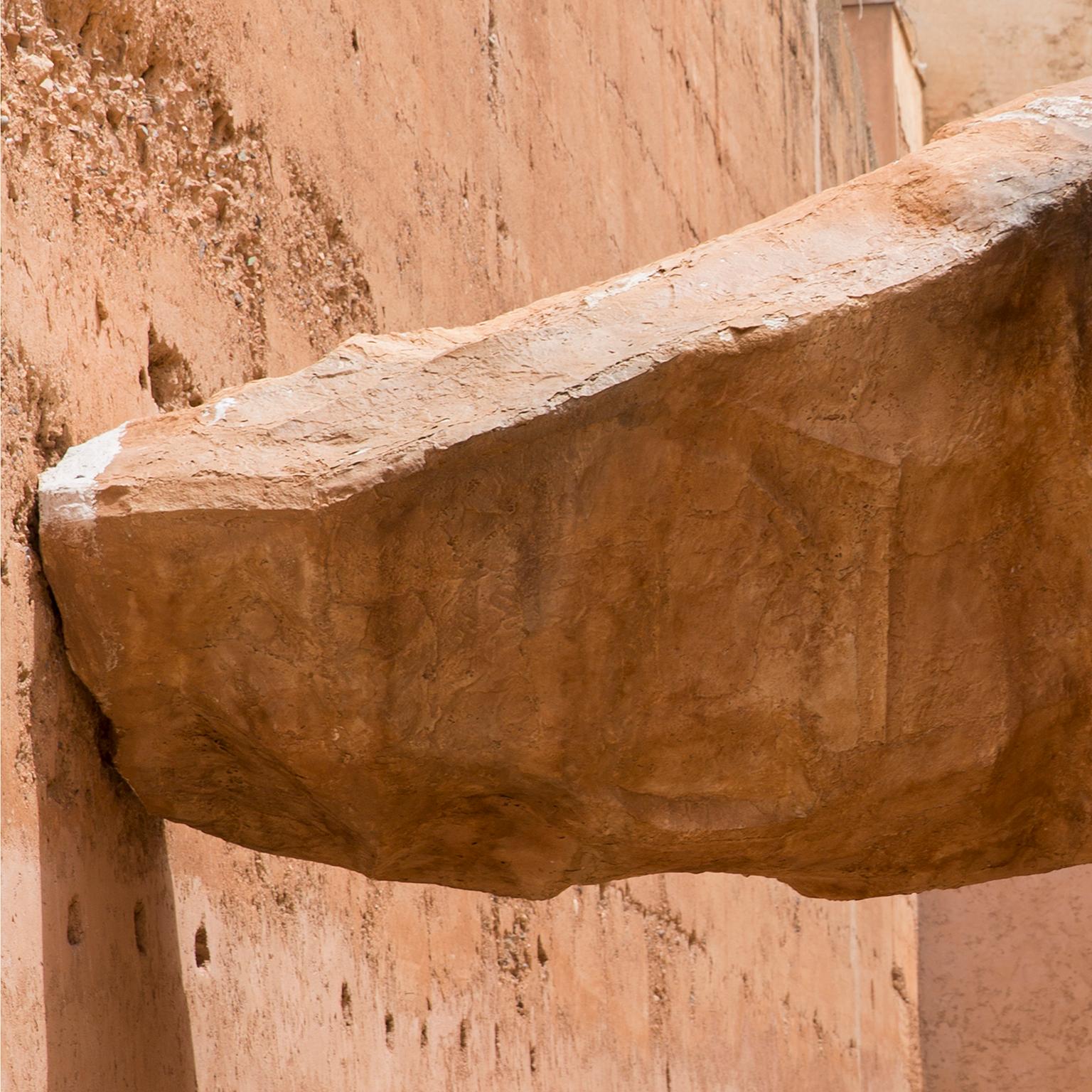 Impossible balancing act.  Marrakesh, Morocco, 2016
Photograph by Cosmo Condina. An impossibly large  rock supported by two walls in a courtyard.
Archival pigment print 19 X 12.45 in.  Edition of 10. This is # 3/10 in the edition.

 'Palace of