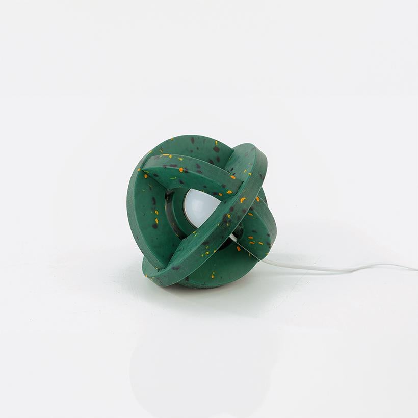 The COSMO LAMP, a miniature universe on your table, invites you to create a unique masterpiece from recycled plastic components. By day, it stands as a serene, artistic presence, reminiscent of a quiet planet. By night, it transforms into an