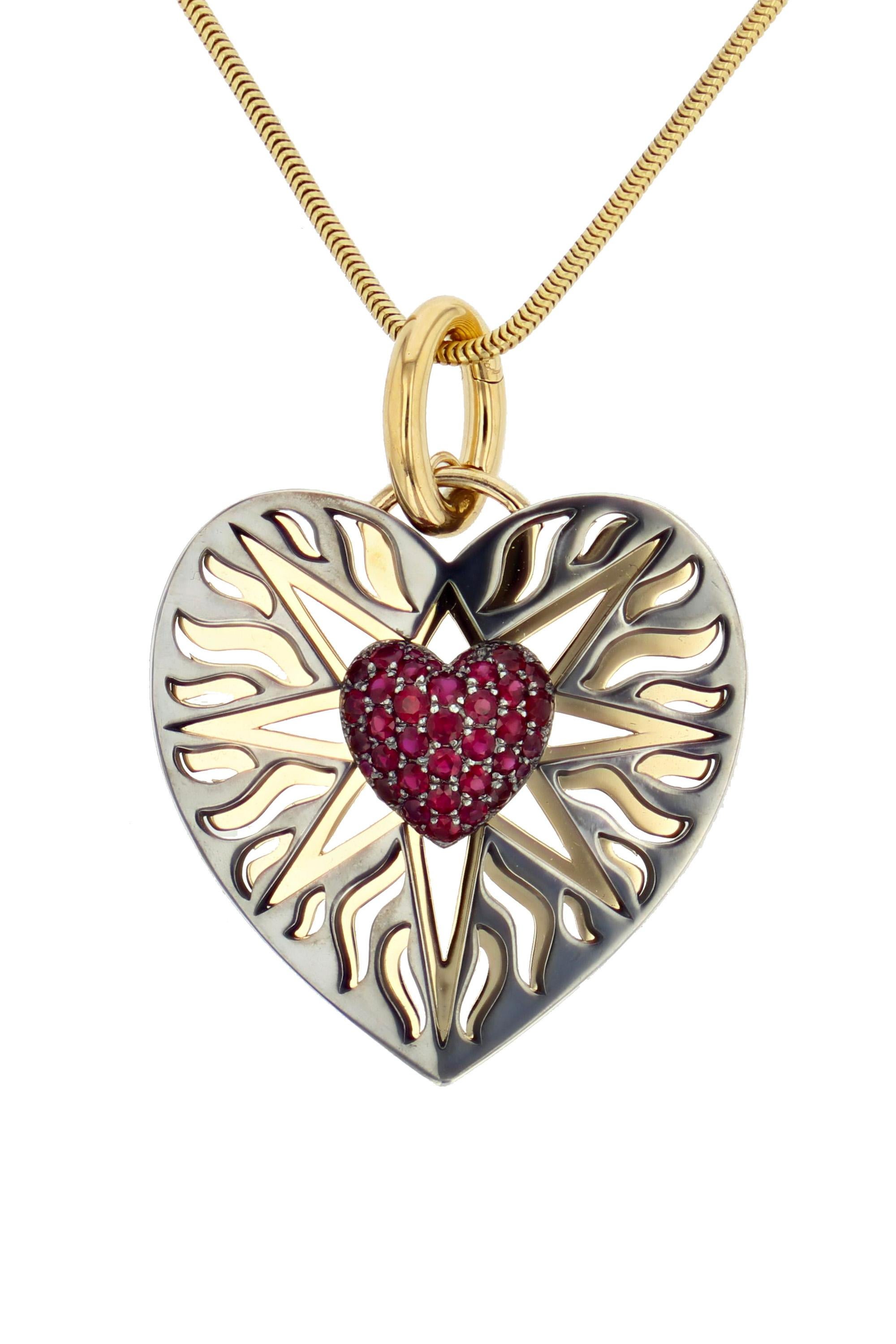 Yellow gold and distressed silver charm, with a heart set with rubies in its center. Openable gold bail. 

Sold without the chain. 

Available with chain on request.

Details:
Ruby: 0.9 cts
18k Yellow Gold: 9 g
Distressed silver: 6 g
Made in France