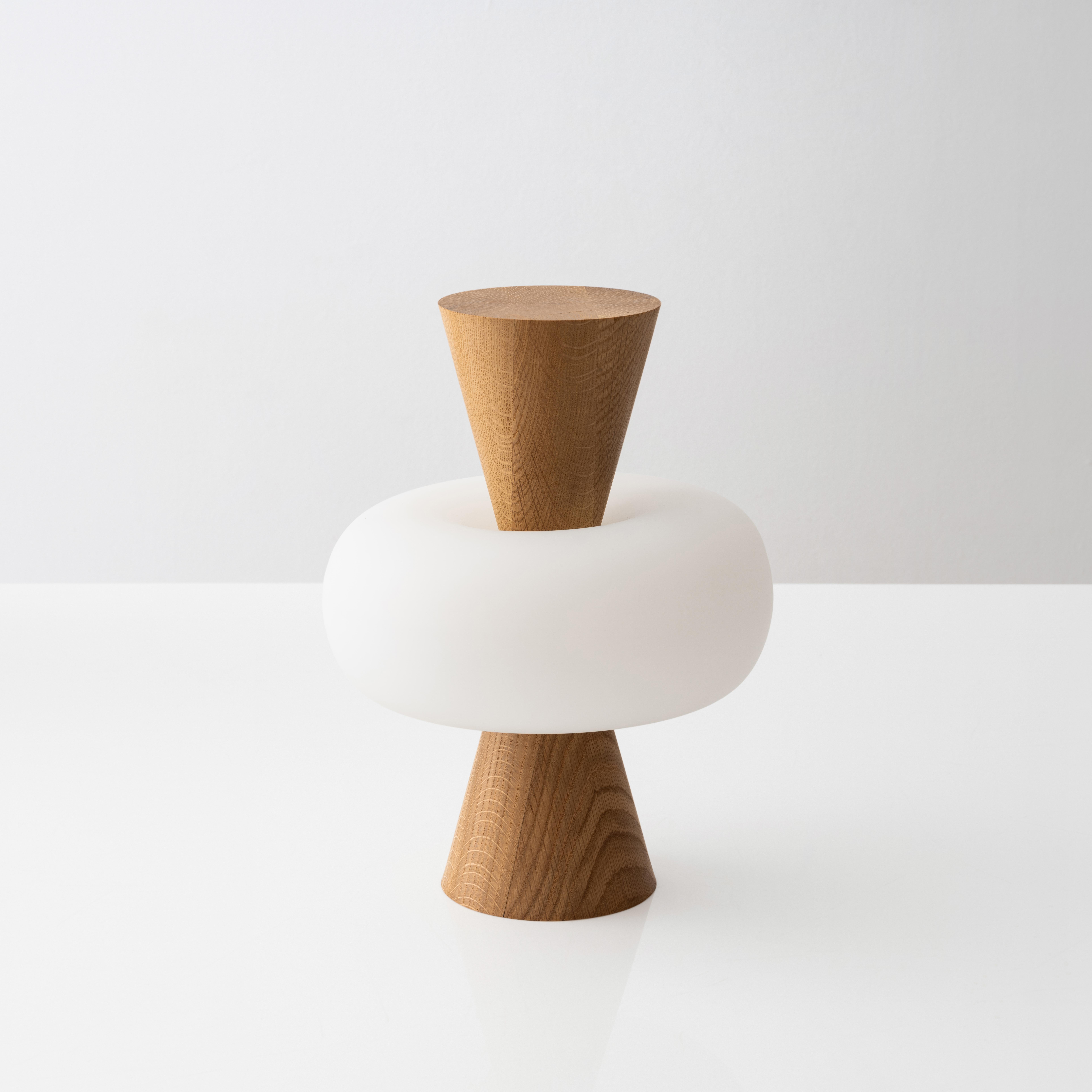 Cosmos 06 Table Lamp by Noiro Studio
Dimensions: D 25 x H 35 cm.
Materials: Glass, oak.

Handcrafted in New York City using the finest glass-blowing techniques, our Cosmos collection is a truly unique piece of art. Inspired by the captivating torus