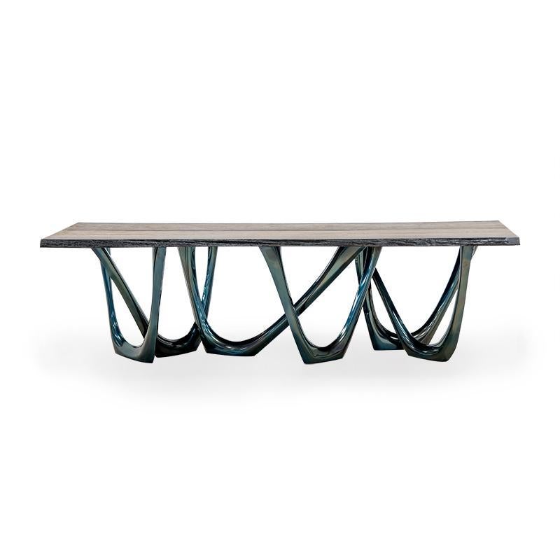 Comos Ancient oak G-Table by Zieta
Dimensions: D 116 x W 260 x H 75 cm 
Material: Bog oak top. Carbon steel base. 
Finish: Thermal colored in cosmic blue.
Available in finishes: Concrete, stainless steel, wood top, and aluminum. Also available in