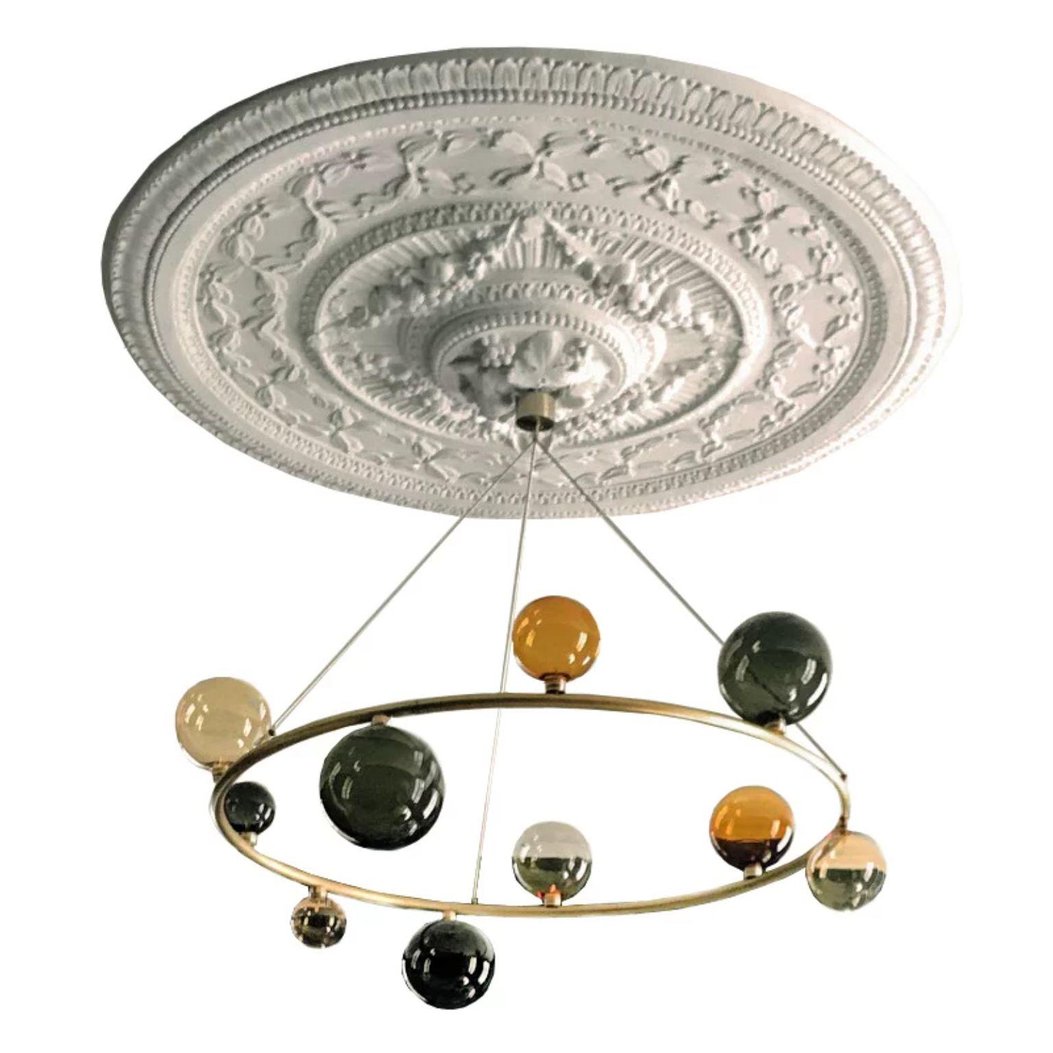 Cosmos ceiling lighting by Emilie Lemardeley
Dimensions: D110 x H70 cm
Materials: Brushed brass, 10 glass spheres.
Weight: 15 kg

The cosmos collection references to the old occidental belief that the Earth was the center of the universe.