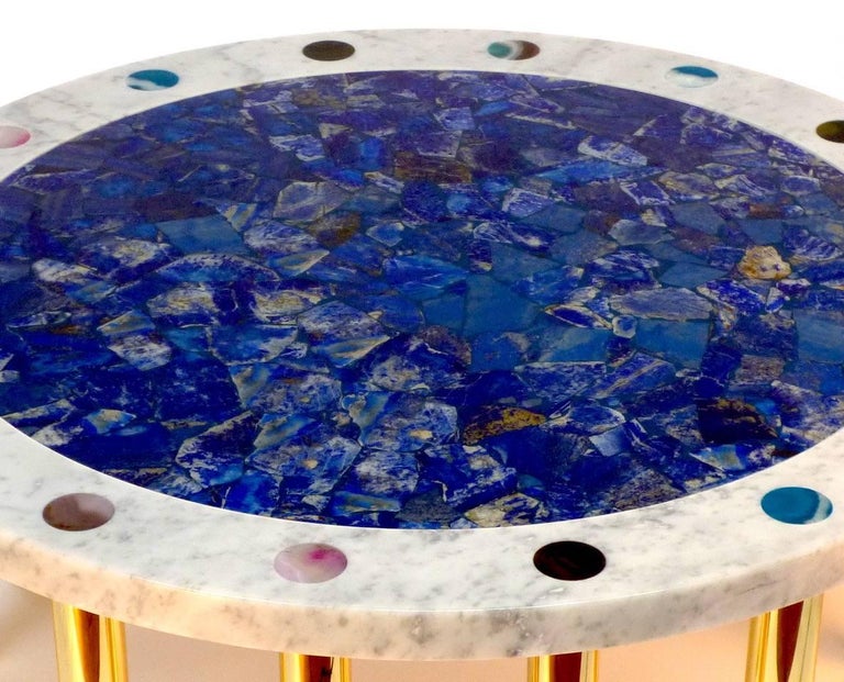 Cosmos coffee table with central circle in Lapis Lazuli mosaic and outer circle in white Carrara marble decorated with agate disks of different colors, with brass legs, designed and produced by Studio Superego in 2018. 
The thickness of the marble