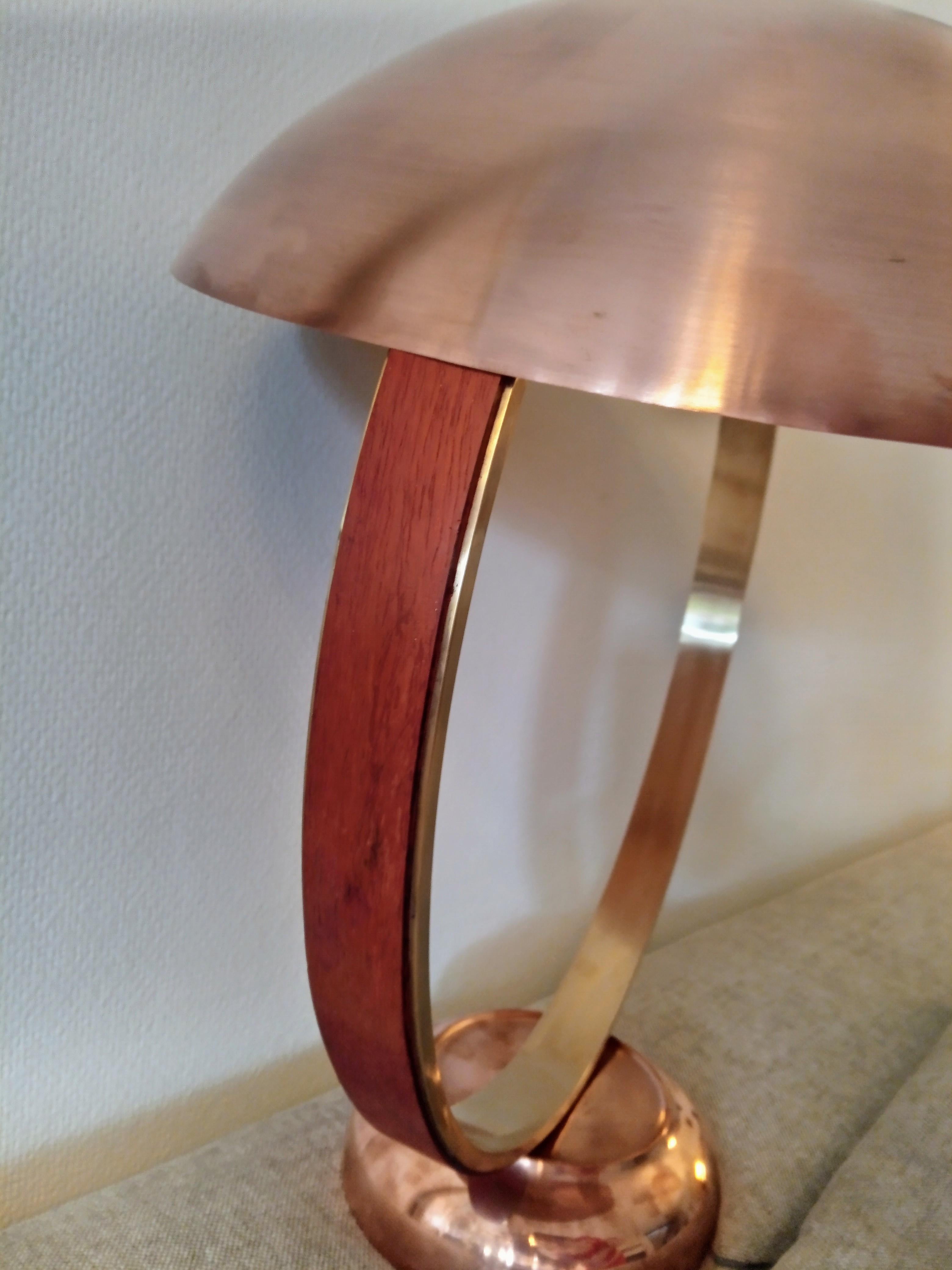 This table lamp is made of brass, brushed inside and outside. The ring is covered with wood: padouk or multiplex berch.
 
There are 2 led ball lamps E27 socket under the lampshade.