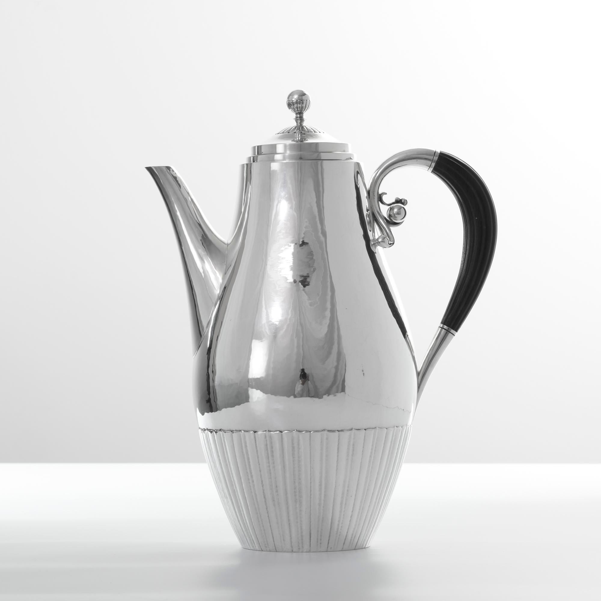 Diese 1915 von Johan Rohde entworfene Kaffeekanne aus Sterlingsilber mit dem Namen Cosmos wurde nach 1945 von dem Silberschmied Georg Jensen in Dänemark hergestellt. Dieses Stück ist vollständig handgefertigt, mit gegossenen Details und einem