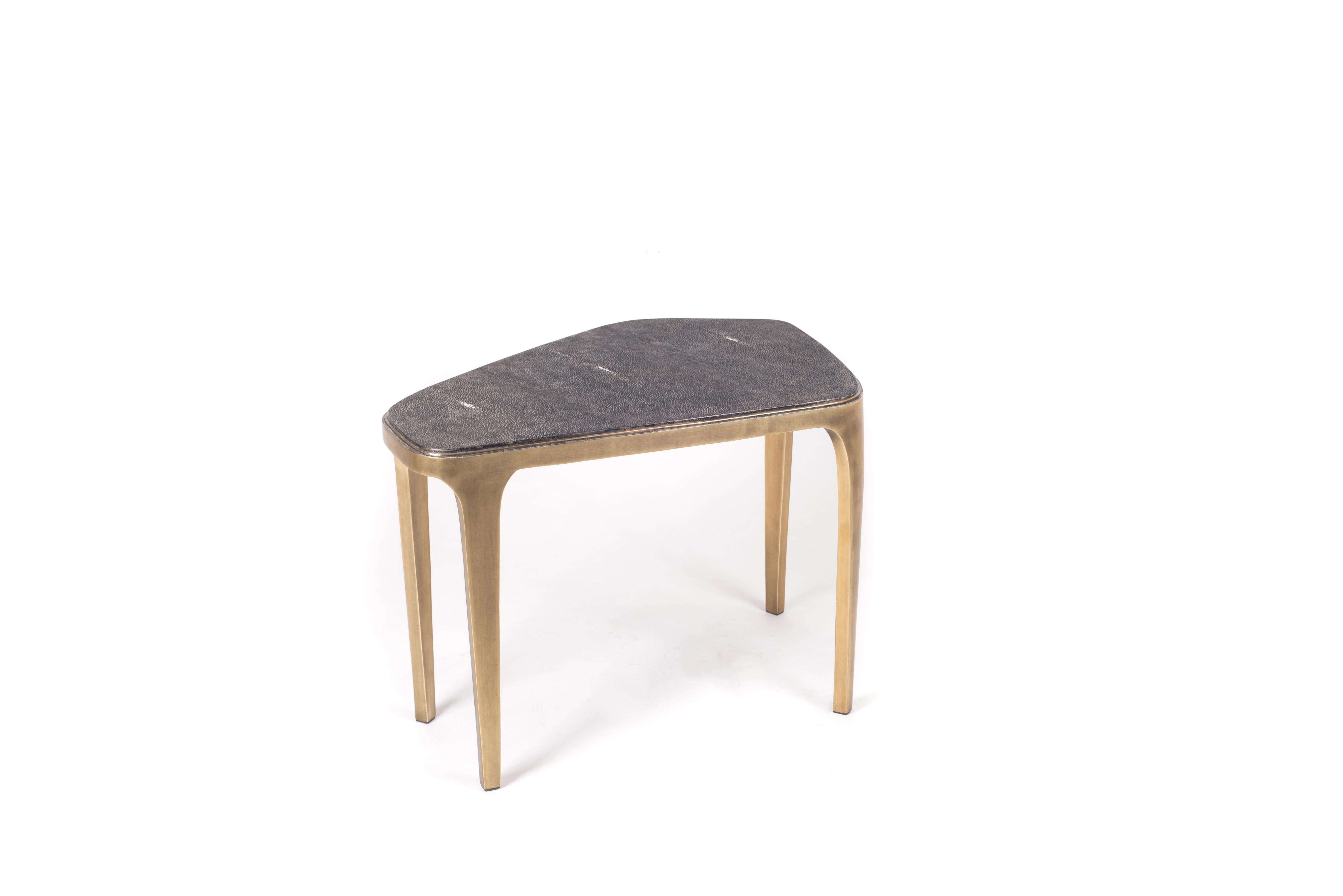 La table basse gigogne Cosmos est à la fois minimaliste et spectaculaire. Le plateau est incrusté de galuchat noir, teinté à la main par les artisans, et complété par du laiton bronze-patiné. Le designer appelle cette finition le galuchat 